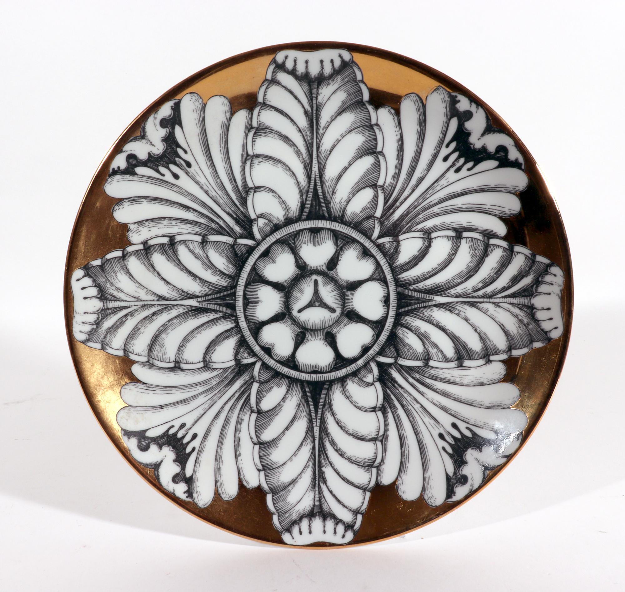 Vintage Set of Six Piero Fornasetti Porcelain Rosoni pattern plates depicting Rosettes
1980s,

The dramatic plates depict six different large black and white flower-shaped rosettes on a gilt ground. 

Dimensions: 10 inches diameter x 1 1/4