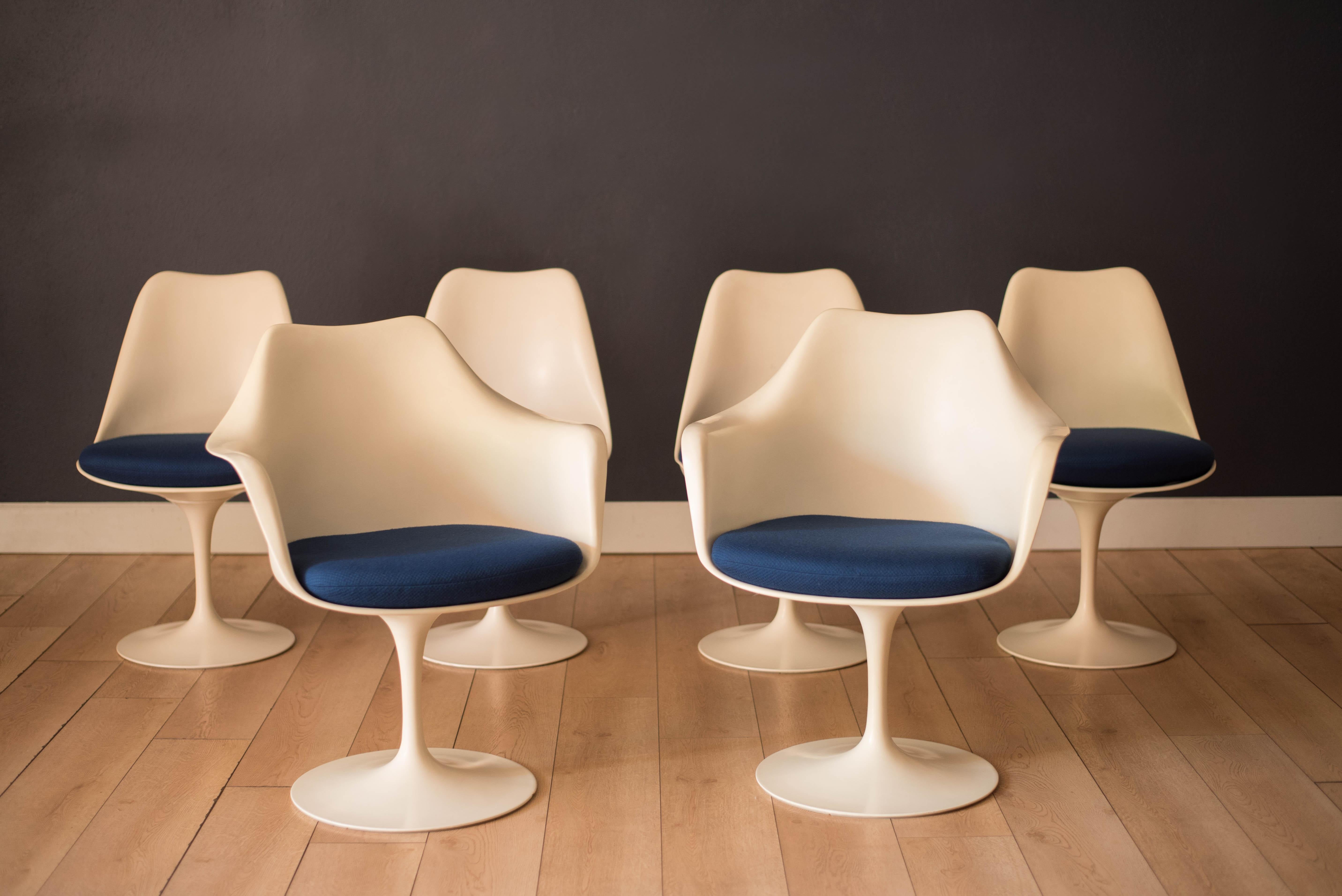 Mid century modern tulip dining chairs designed by Eero Saarinen for Knoll Associates from the Pedestal Collection, circa 1960's. This contrasting set includes two armchairs and four side chairs that swivel and retain the original blue fabric seats