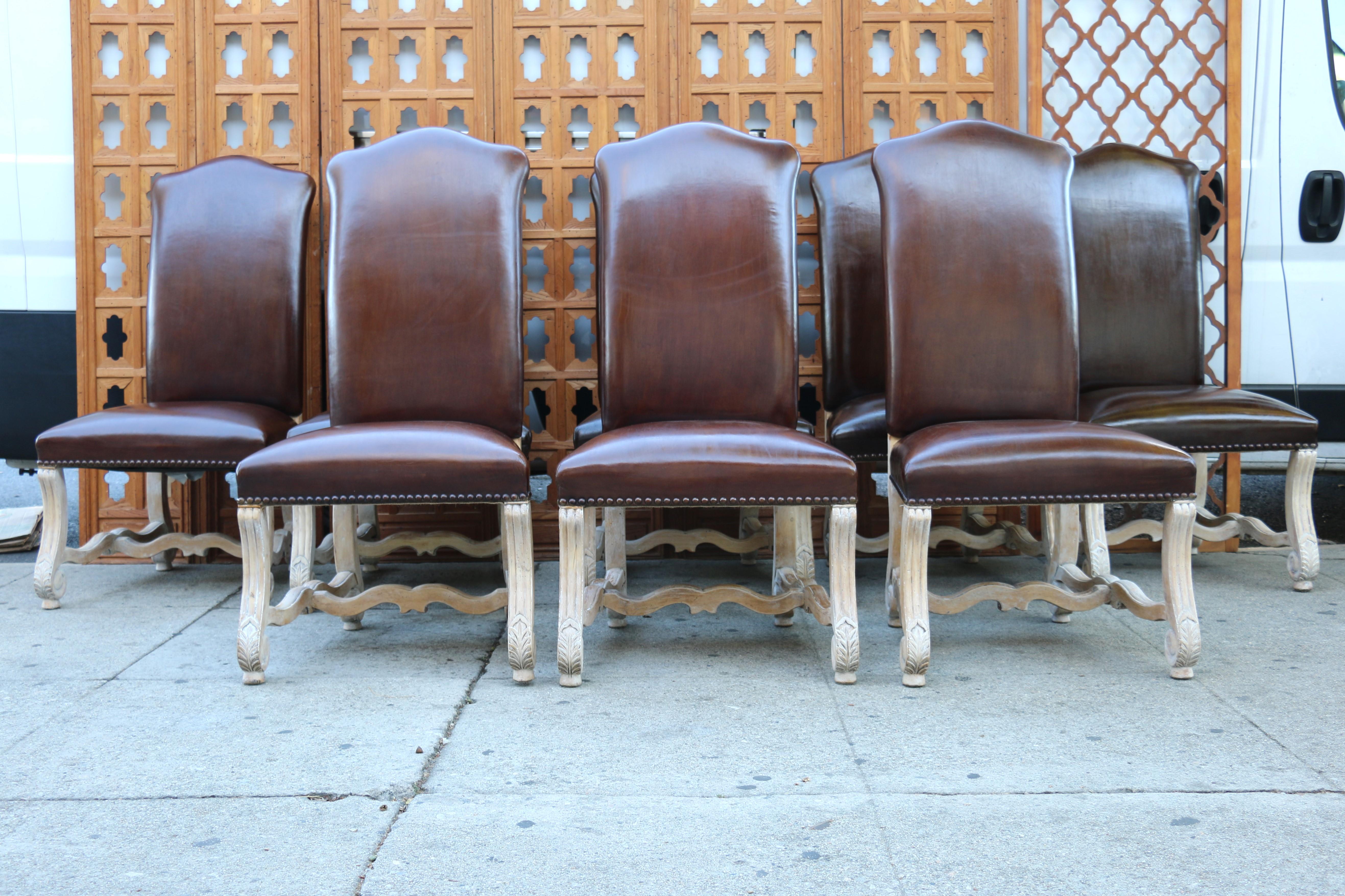 Gorgeous set of ten dining chairs made of leather and solid wood, with burlap in the bottom. These amazing chairs have different tones of brown. They are eight regular chairs and two armchairs. The condition of the chairs is absolutely great. They