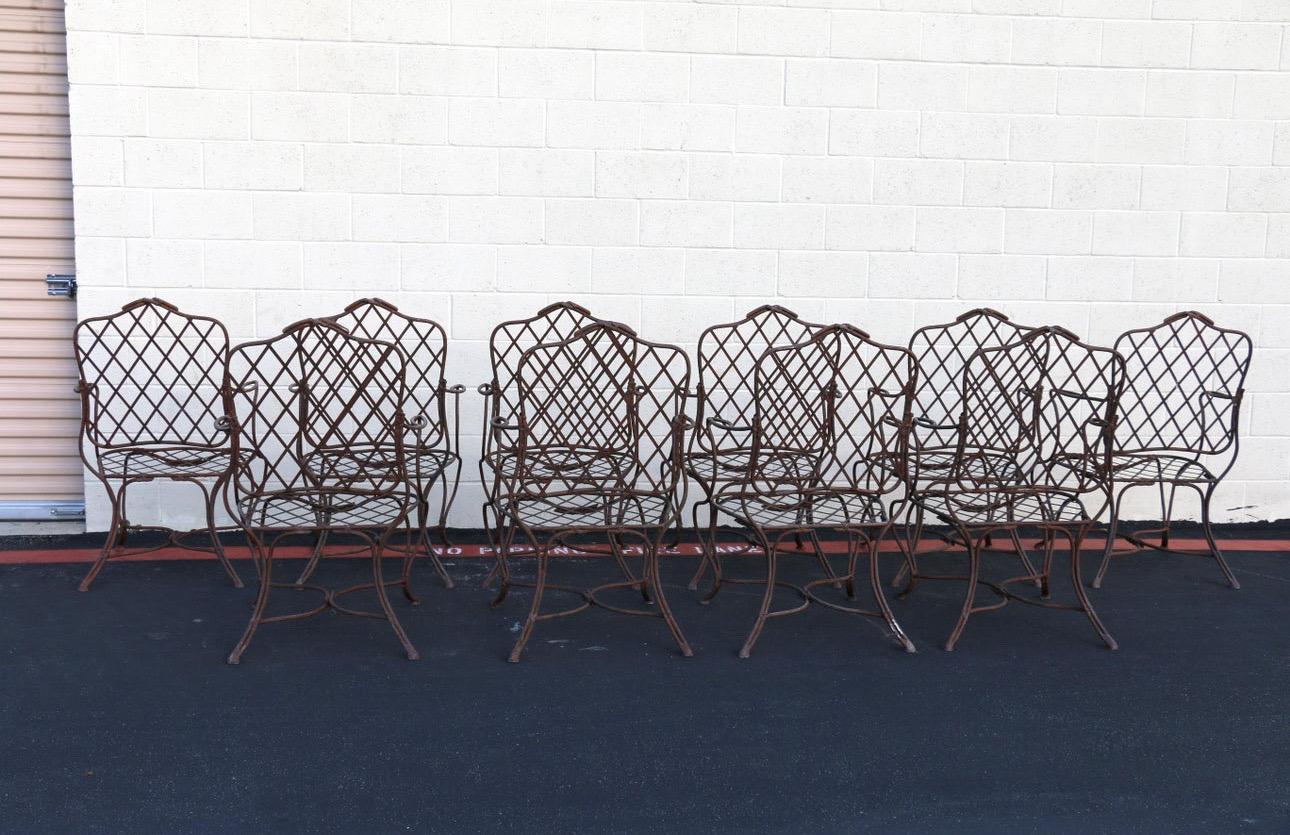 Spectacular set of ten garden dining armchairs manufactured and designed by Gregorius Pineo, Los Angeles, CA. They do Not have designer masks. These wonderful patio armchairs features faux bois twig iron frames. They are very solid and sturdy. They