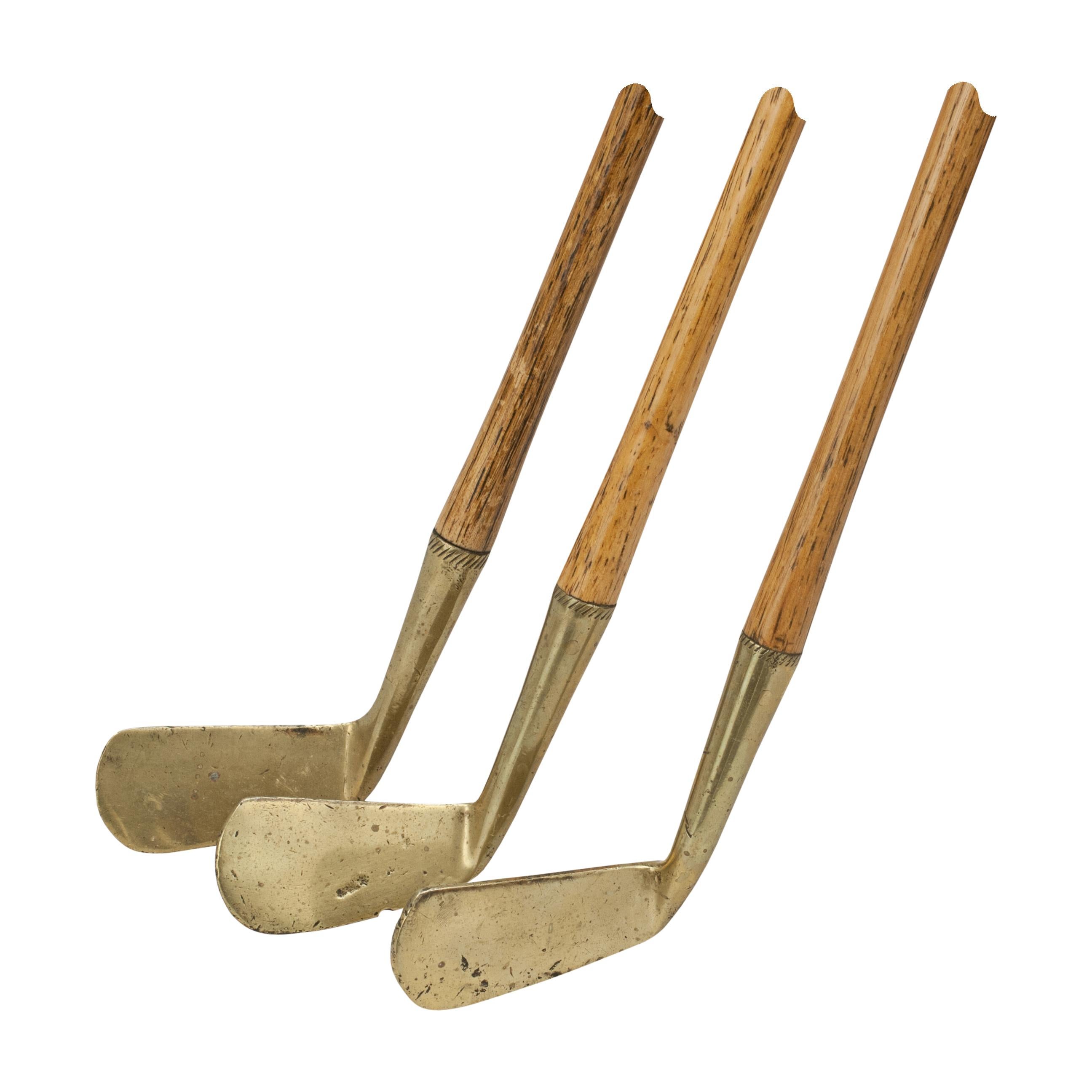 Halley & Co. Children's Hickory Golf Clubs.
Set of three child's golf clubs comprising of a iron, a mashie and a putter. All are with suede leather grips and brass heads stamped with Halley's 