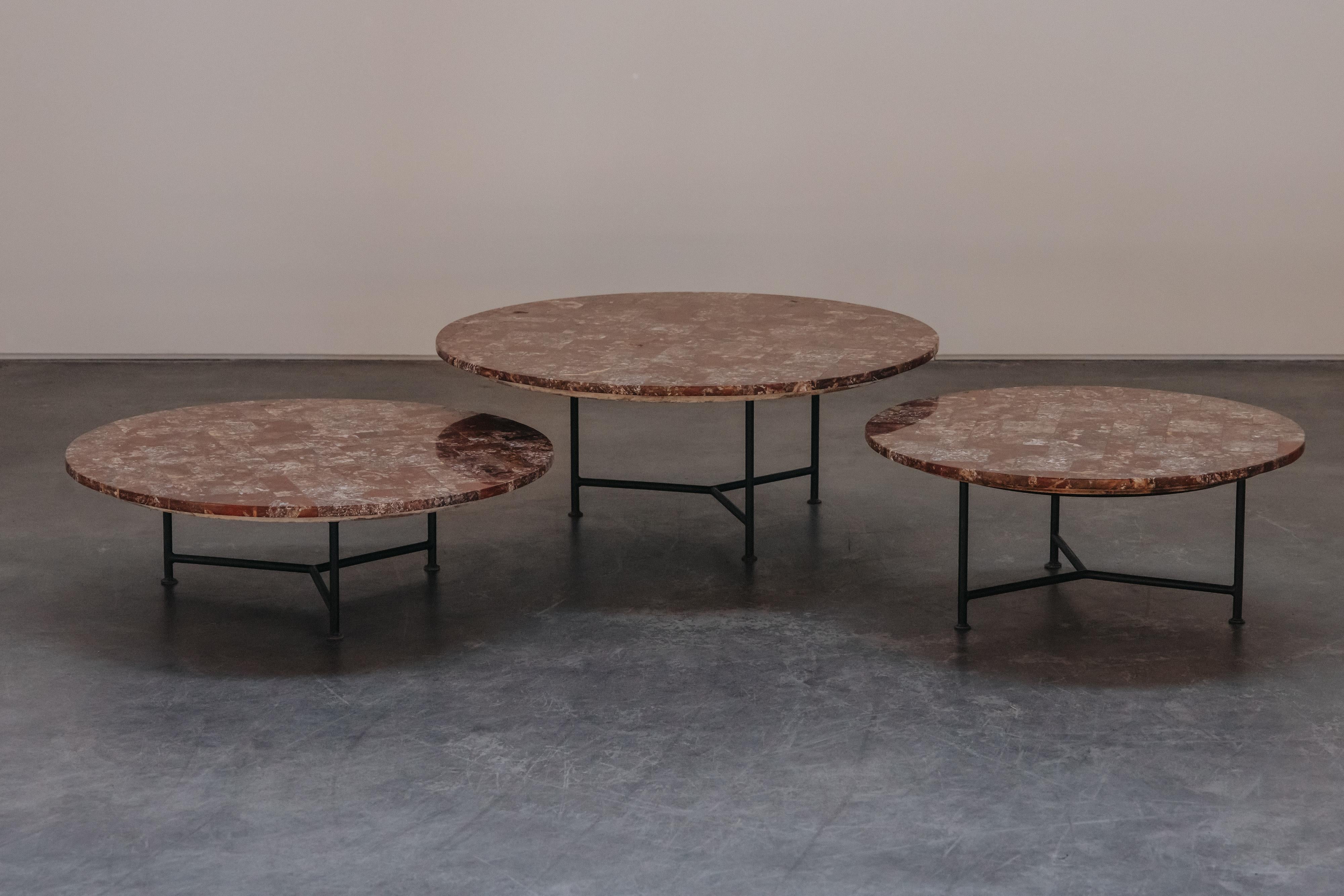 Vintage Set Of Three Marble Nesting Coffee Tables From France, Circa 1960.  Solid marble tops that rest on a black metal base.  Dims listed are of the largest one.  The other two tables measure:
H - 13.5 / W - 31.5
H - 11 / W - 35
Very light patina