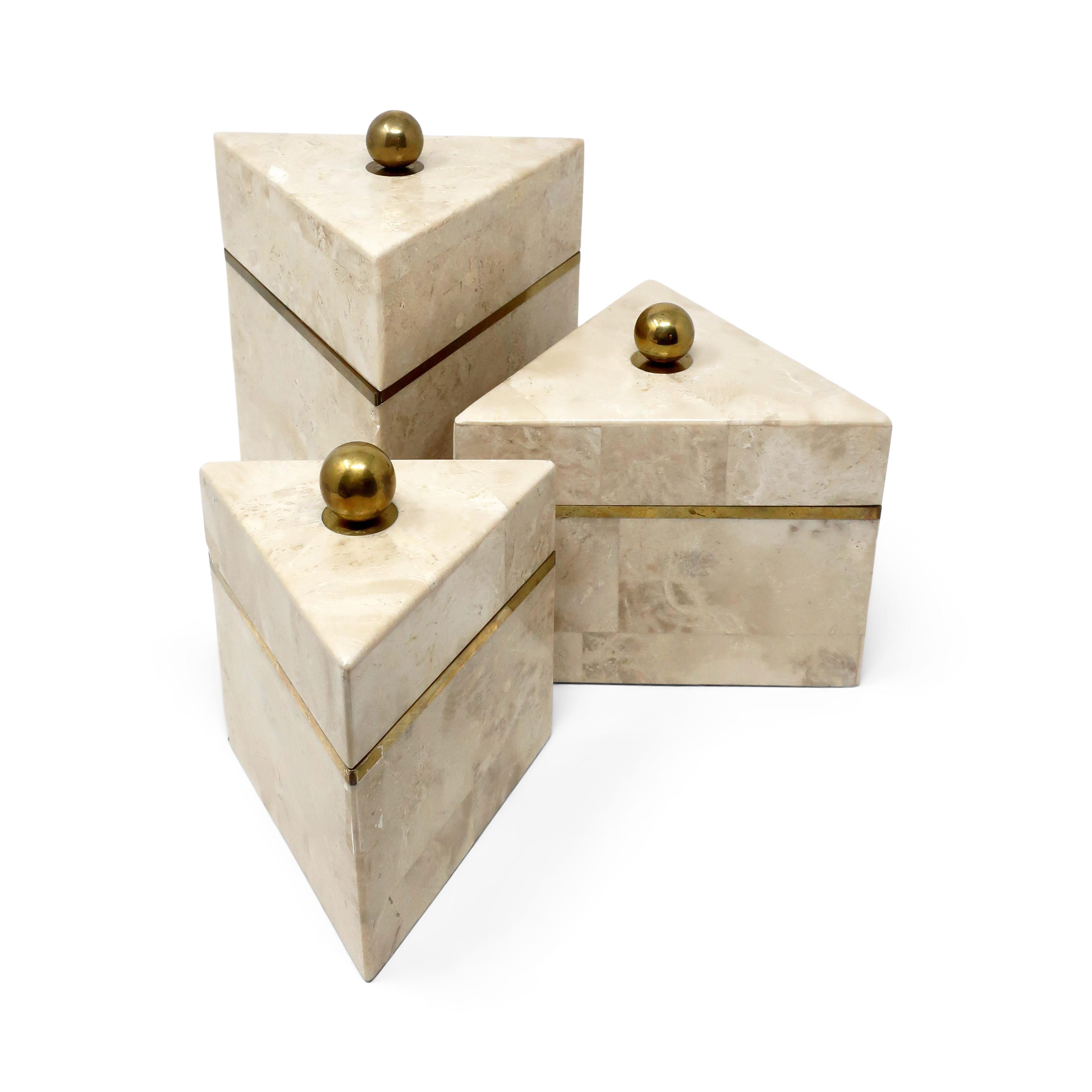 An elegant set of three vintage tessellated stone boxes (possibly marble or travertine) with brass accents from the 1970s or 1980s attributed to Maitland-Smith. A triangular shape with each box increasing in size. Each has a round brass pull on top,