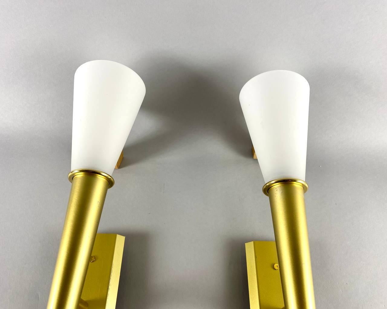 Elegantes Wandleuchtenpaar aus weißem Glas in konischer Form mit goldfarbenem, gebürstetem Metallrahmen von WOFI Leuchten, Deutschland.

Ein einfaches und elegantes Design. Weißes Glas und goldfarbenes, gebürstetes Metall vereinen sich zu diesem