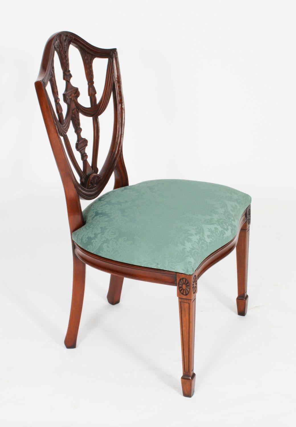 Il s'agit d'un ensemble absolument fantastique de vingt chaises de salle à manger à dossier bouclier de style néo-fédéral, datant de la seconde moitié du 20e siècle.

Ces chaises ont été fabriquées de main de maître dans un magnifique acajou massif,