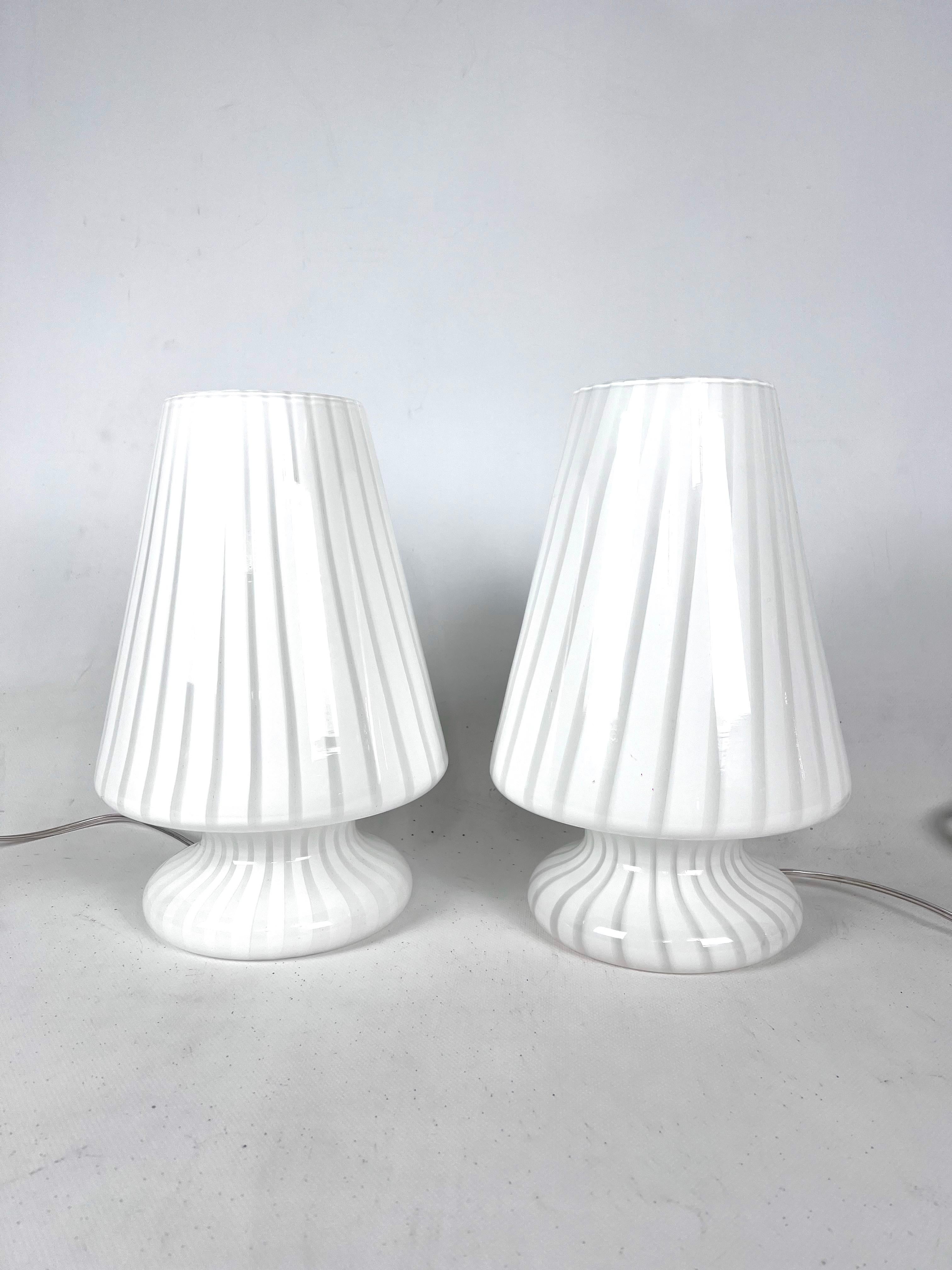 Great vintage condition with slight trace of age and use for this set of two Murano glass table lamps produced in Italy during the 70s. New wiring. Full working with EU standard, adaptable on demand for USA standard.