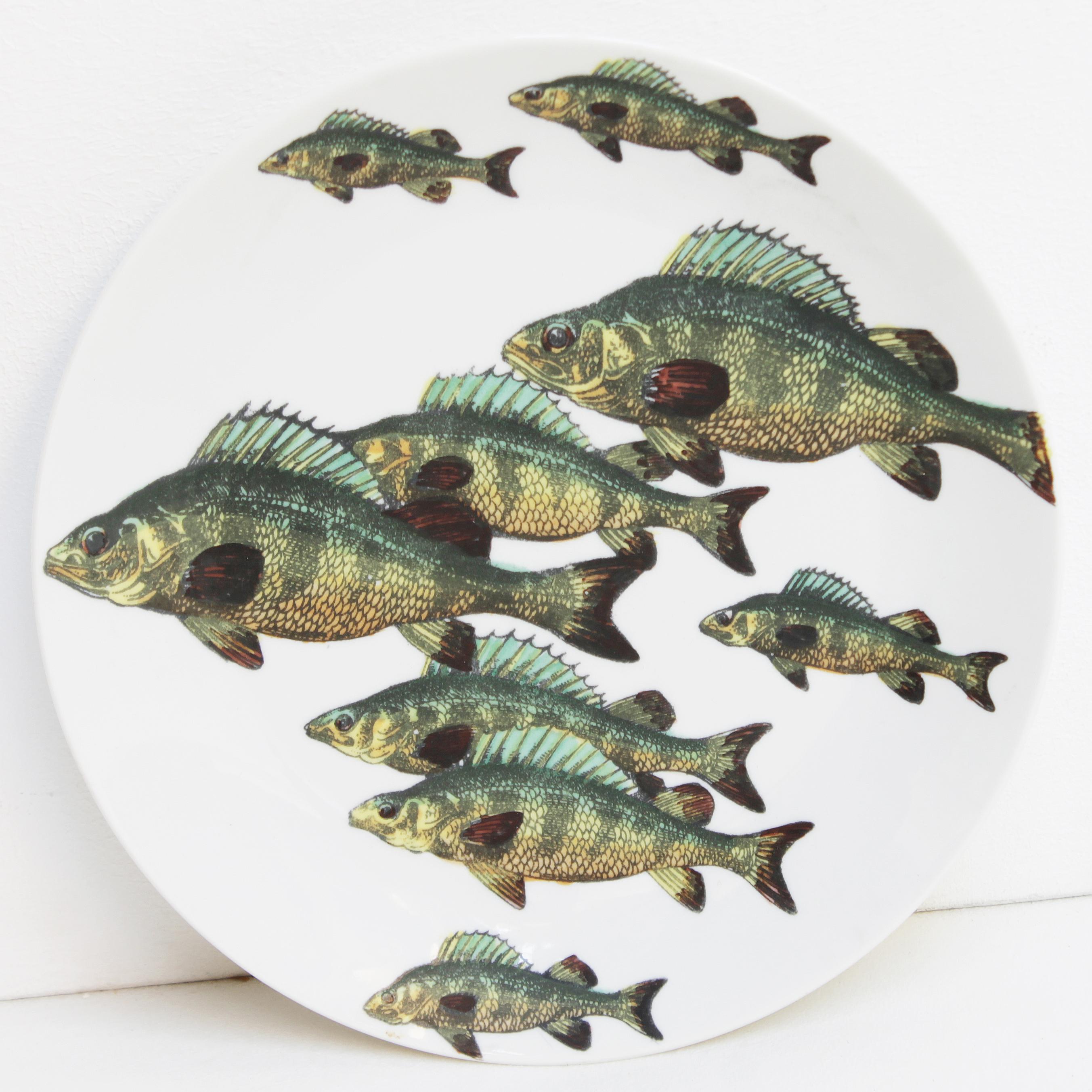 Complete vintage set of six plates 'Passata di Pesce' (Passage of Fish) by Piero Fornasetti 1955. Screen printed in black lines on German porcelain and painted in color by hand in the studio of Fornasetti in Italy. 
The plates are numbered, marked