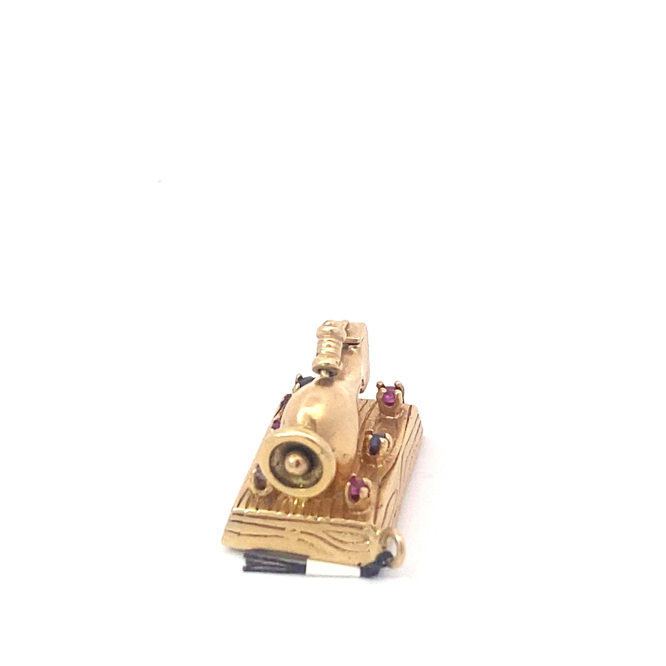 One of a kind vintage charm. This charm is on the larger size, depicting in detail an entire vintage sewing machine with a bobbin of thread. The charm features a ruby and two sapphires set equidistantly across each side of the charm and hangs from a