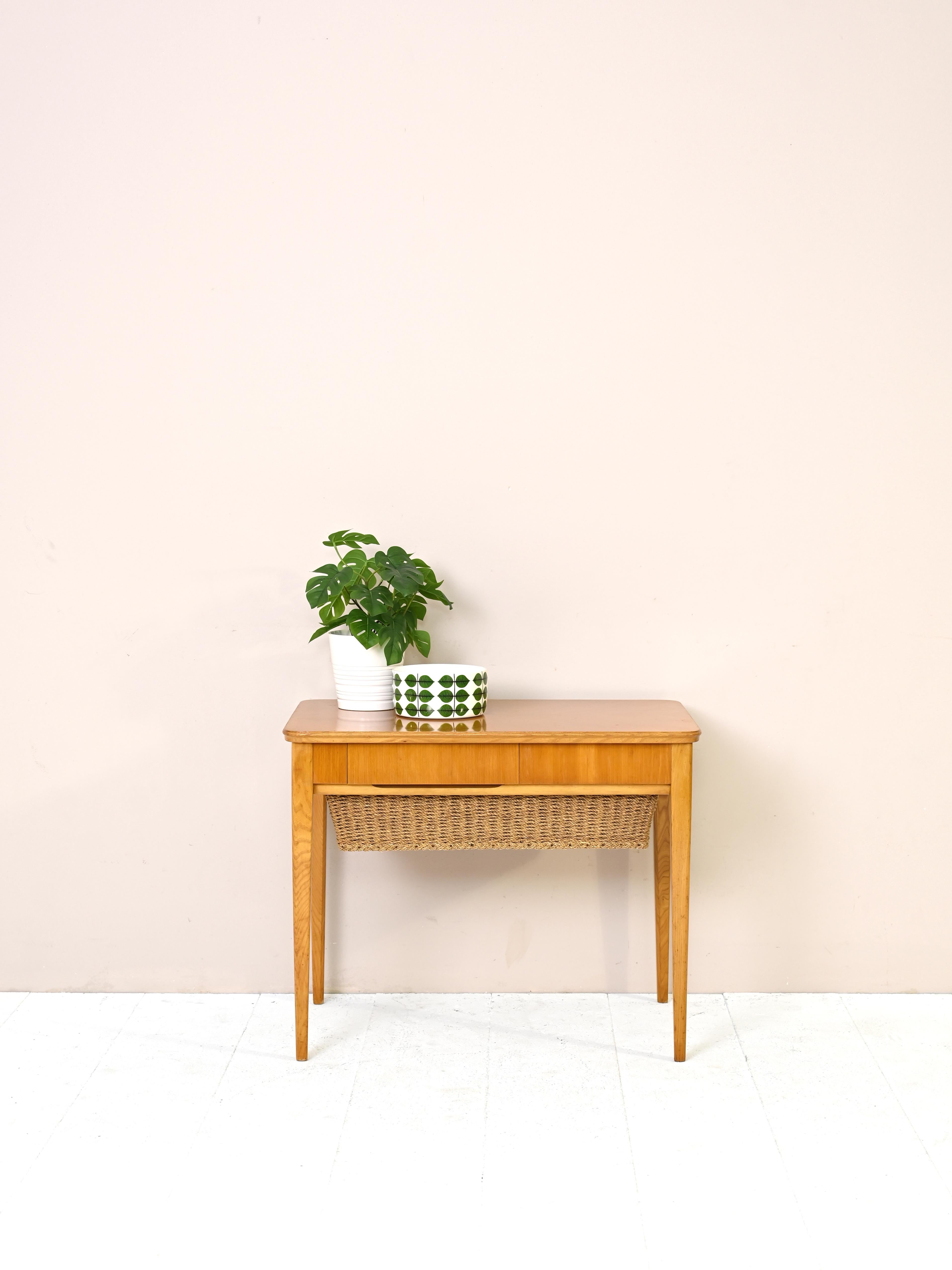 Original piece of Nordic craftsmanship.
This side table, created to hold sewing materials, can be used as a tabletop
shelf and storage cabinet. It also features a small side drawer.
On the top, thanks to the marked wood grain, the color is