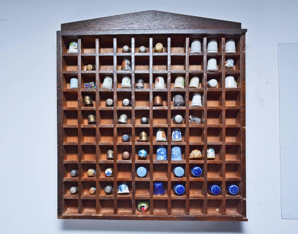 Wonderful small curio display case showing an assemblage of small sewing thimbles with room to collect and display more of your own.