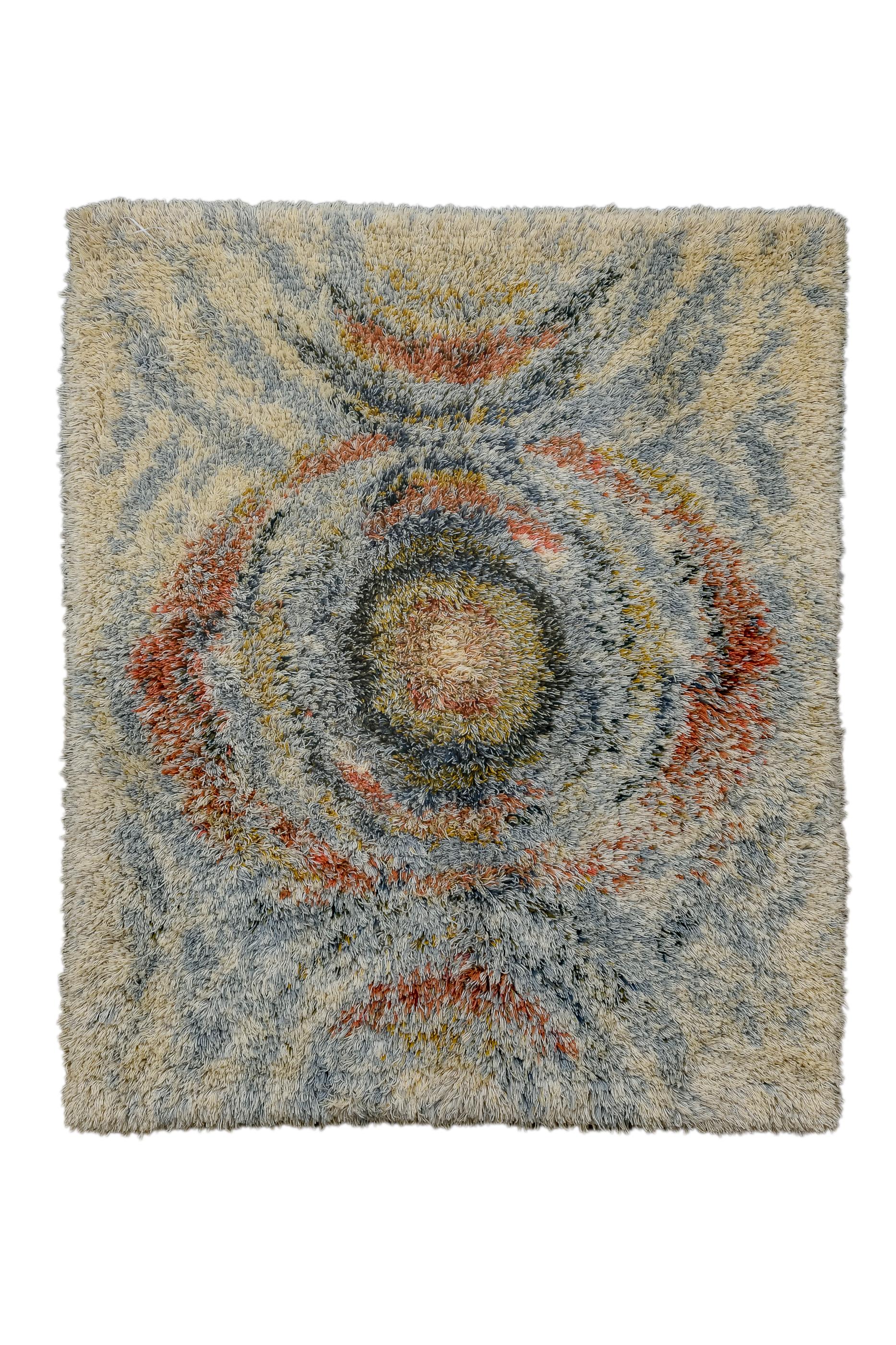 Cette pile exceptionnellement longue et hirsute présente une moitié pleine et deux moitiés flanquantes supérieure et inférieure, de manière grossière et concentrique, avec des tourbillons de rouge, de paille, de bleu et de beige. L'élément central