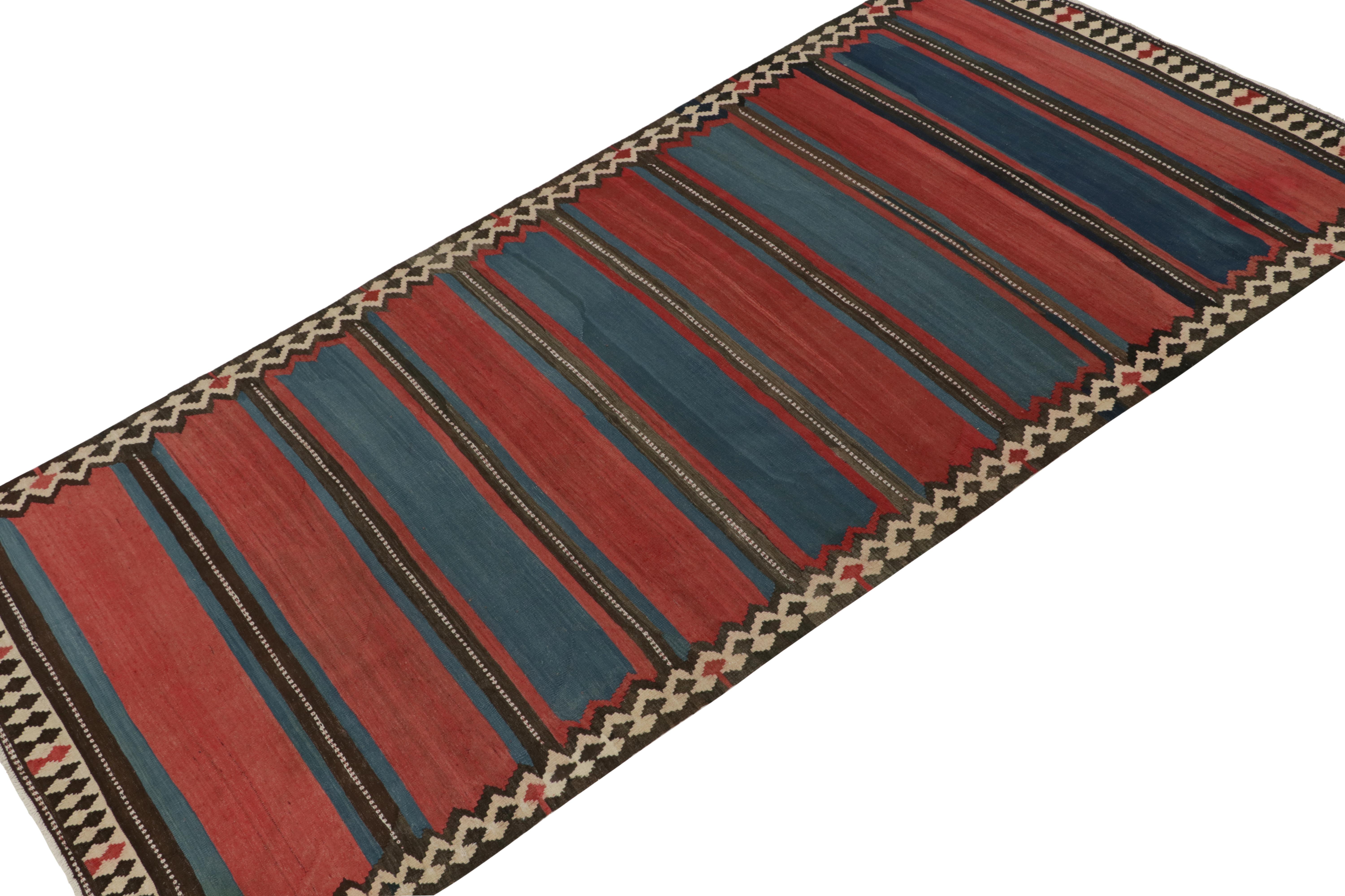 This vintage 6x12 Persian kilim is a tribal rug of Shahsavan provenance. Handwoven in wool, it originates circa 1950-1960.

Further on the Design:

This tribal Kilim favors stripes in brick red and dark blue stripes with beige and brown in the