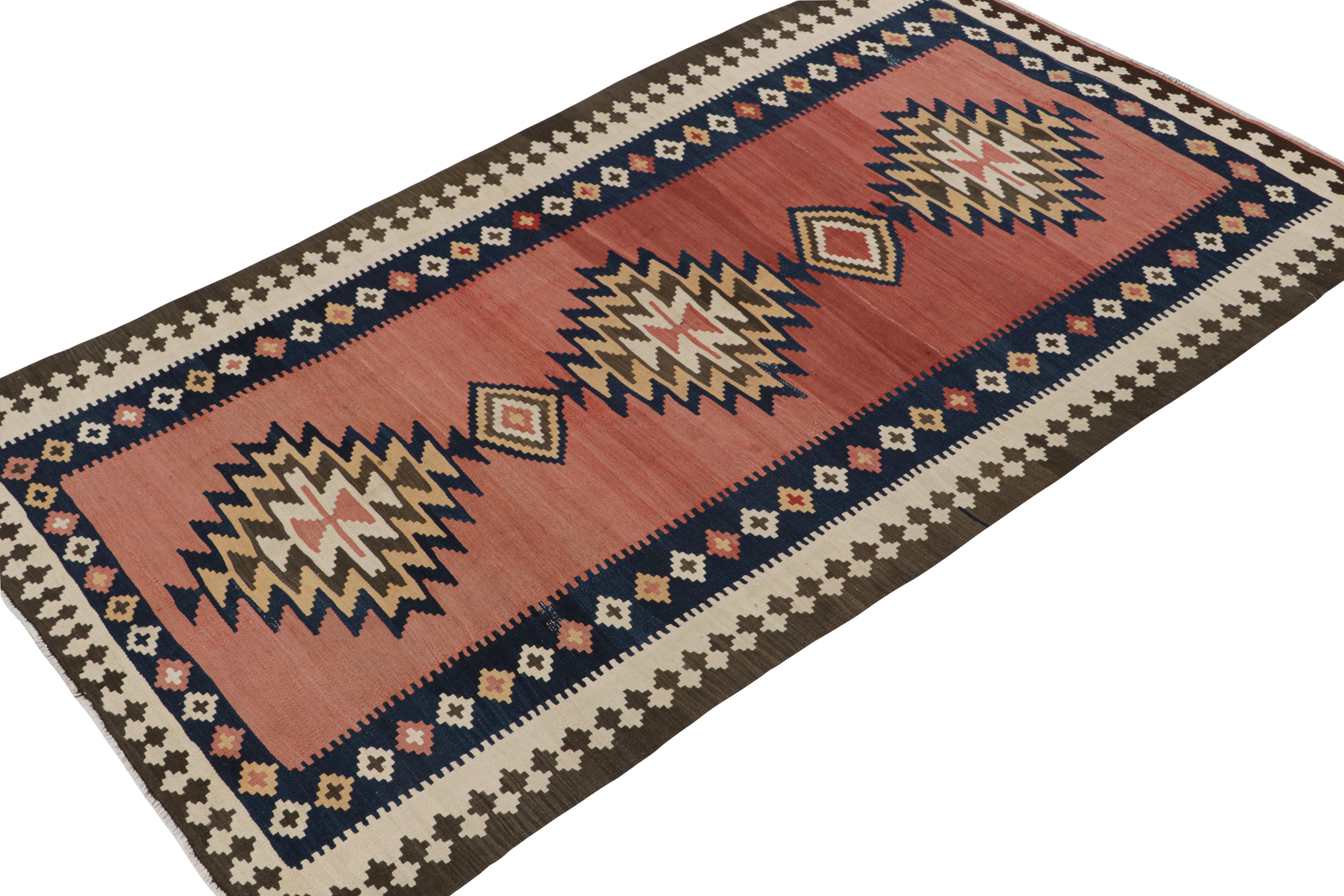 This vintage 5x9 Persian kilim is believed to be a Shahsavan tribal rug. Handwoven in wool, it originates circa 1950-1960. 

Further on the Design:

The design prefers polychromatic medallions on a red open field, wrapped in navy blue and