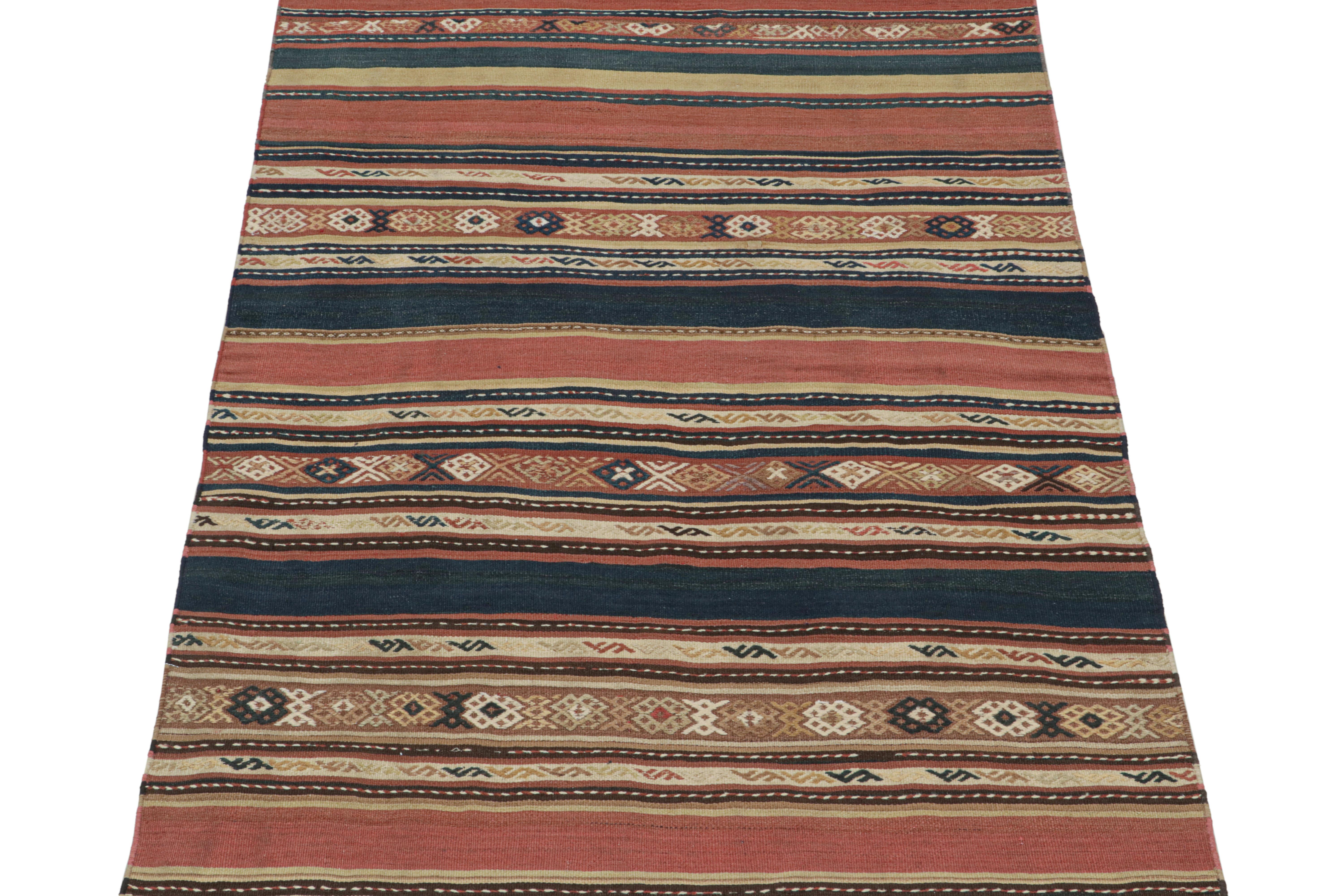 This vintage 5x7 Persian Kilim is a midcentury rug believed to originate from the Shahsavan tribe circa 1950-1960. 

Handwoven in wool, its design favors stripes and traditional geometric patterns in salmon, navy blue and beige-brown tones. Keen