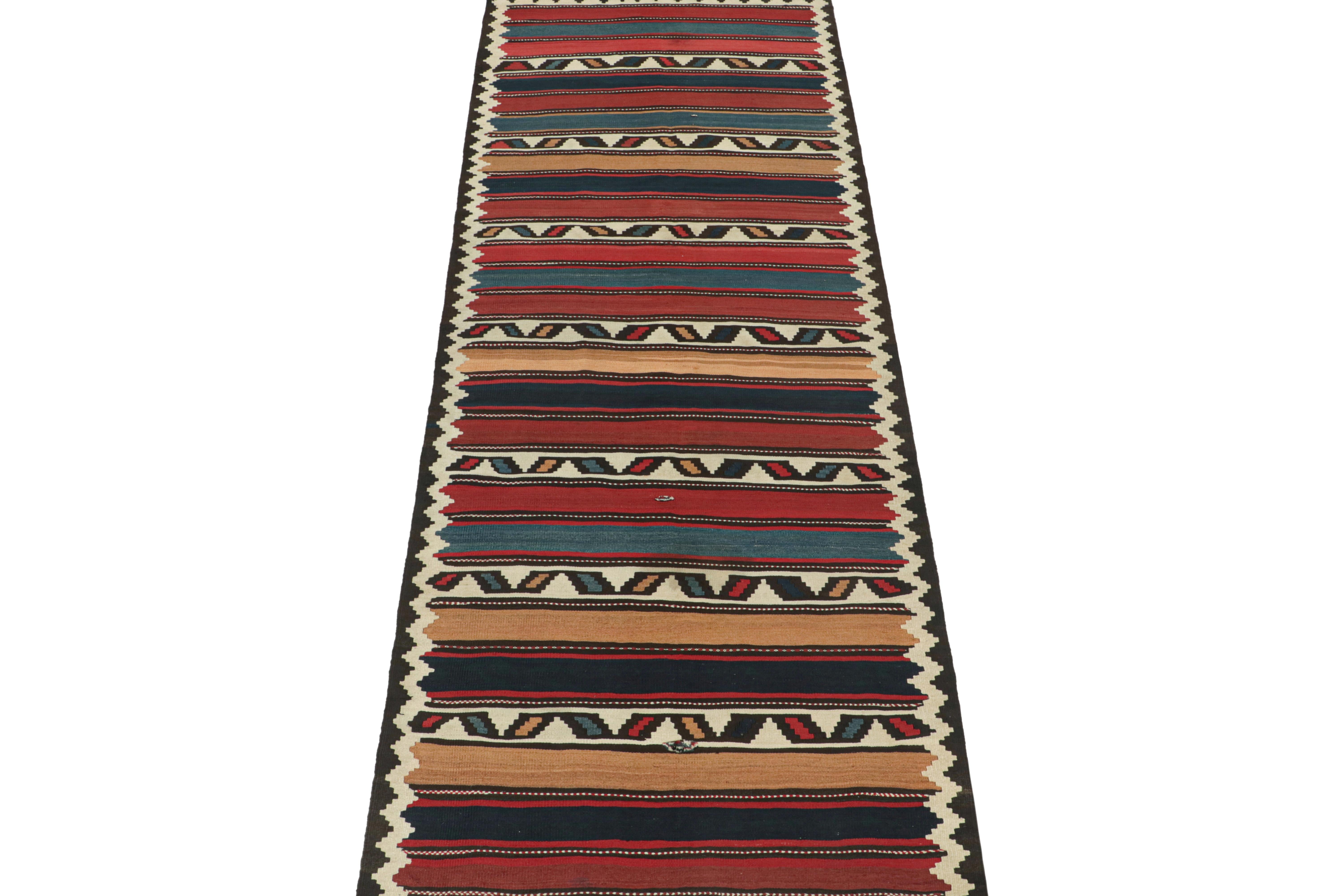 This vintage 5x14 Persian Kilim is a midcentury gallery runner believed to be a Shahsavan tribal rug. 

Handwoven in wool circa 1950-1960, its design favors traditional red, blue, and beige hues in stripes and geometric patterns on a rich brown