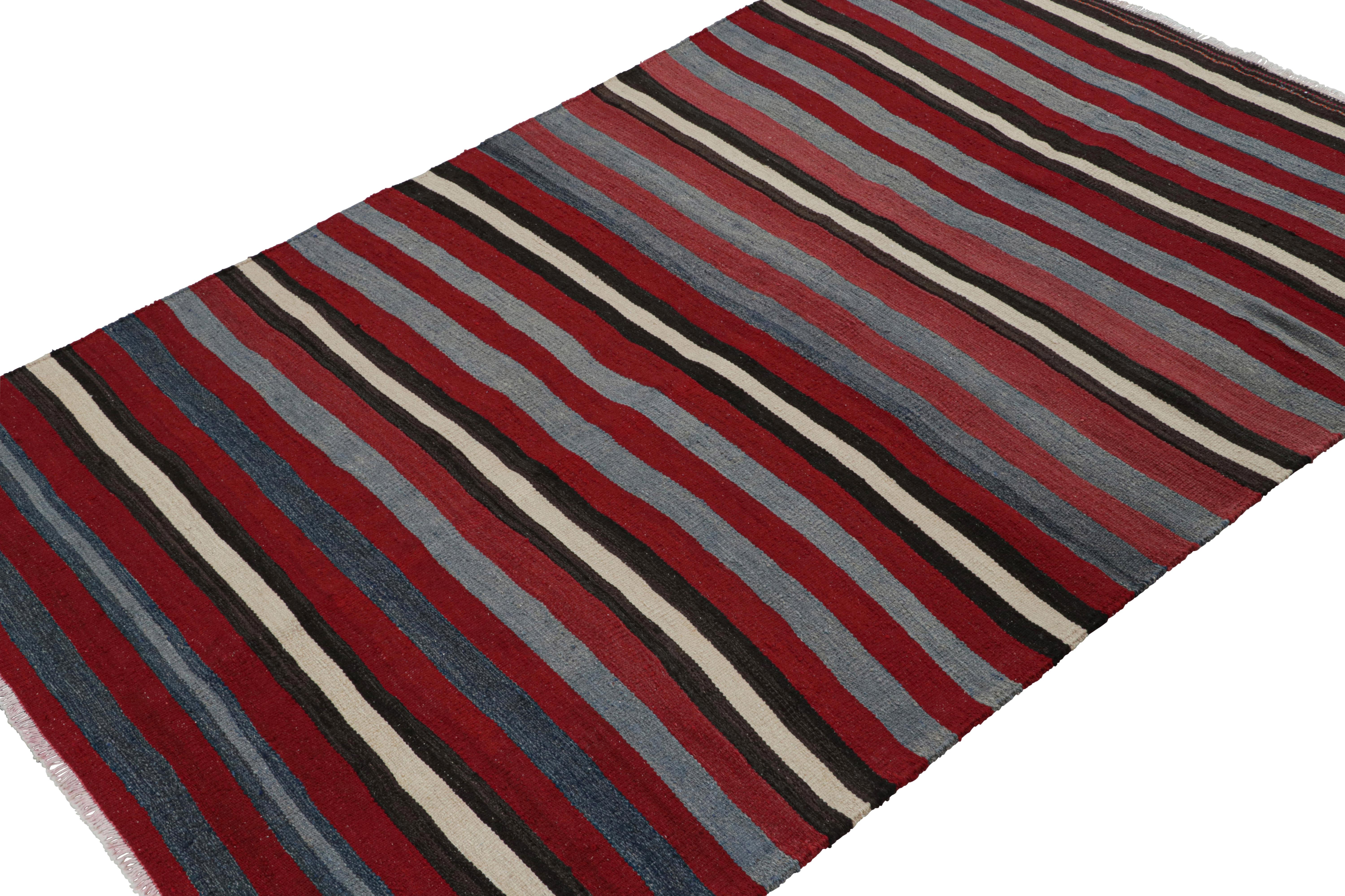 Handwoven in wool, circa 1950-1960, this 4x6 vintage  Shahsavan Persian tribal Kilim rug in red, with silver/gray and blue stripes, is an exciting addition to the Rug & Kilim collection. 

On the Design: 

The Vintage Shahsavan Persian tribal Kilim
