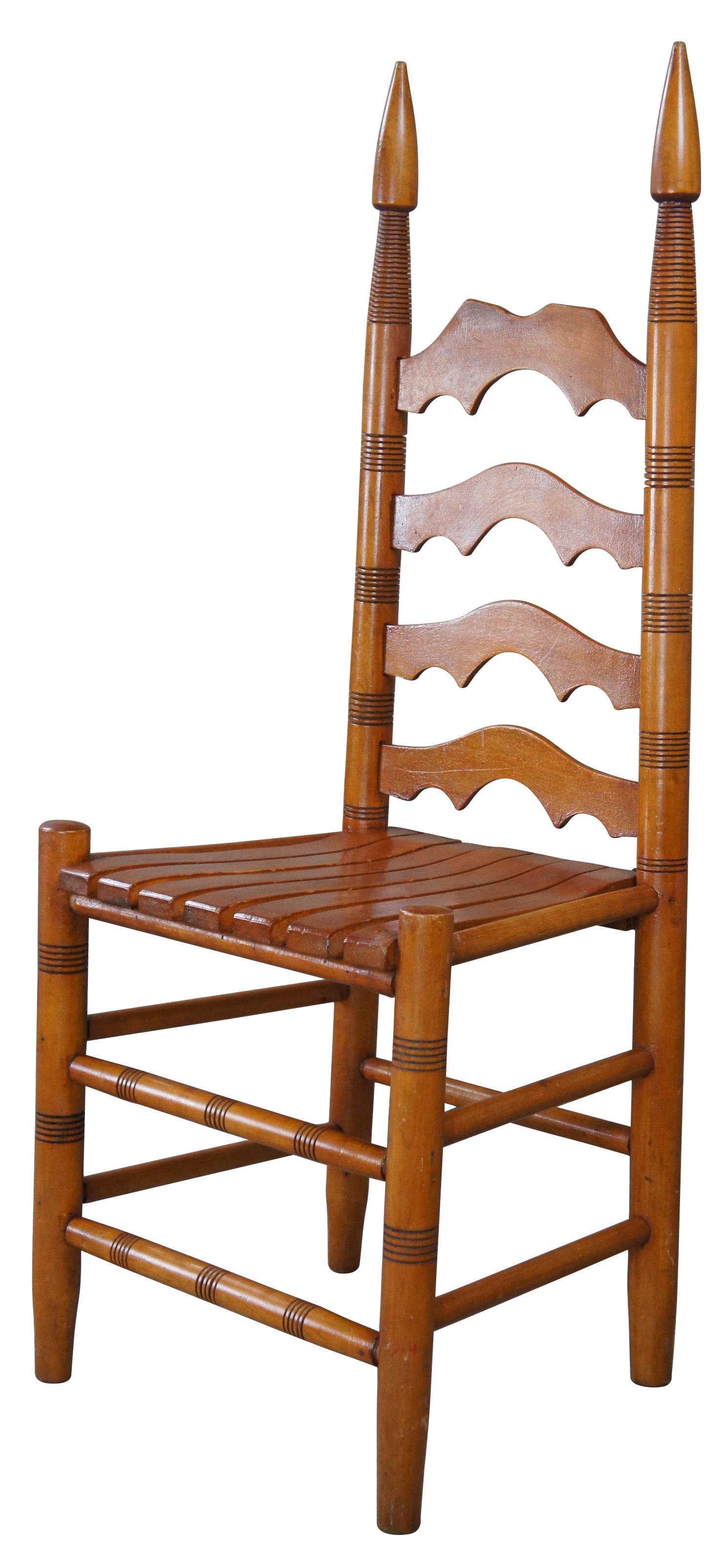20th century arts & crafts side chair. Made from oak with a serpentine ladder back. Features ripped stiles, spire finials and a slatted seat. Legs are turned with ribbed stretchers.