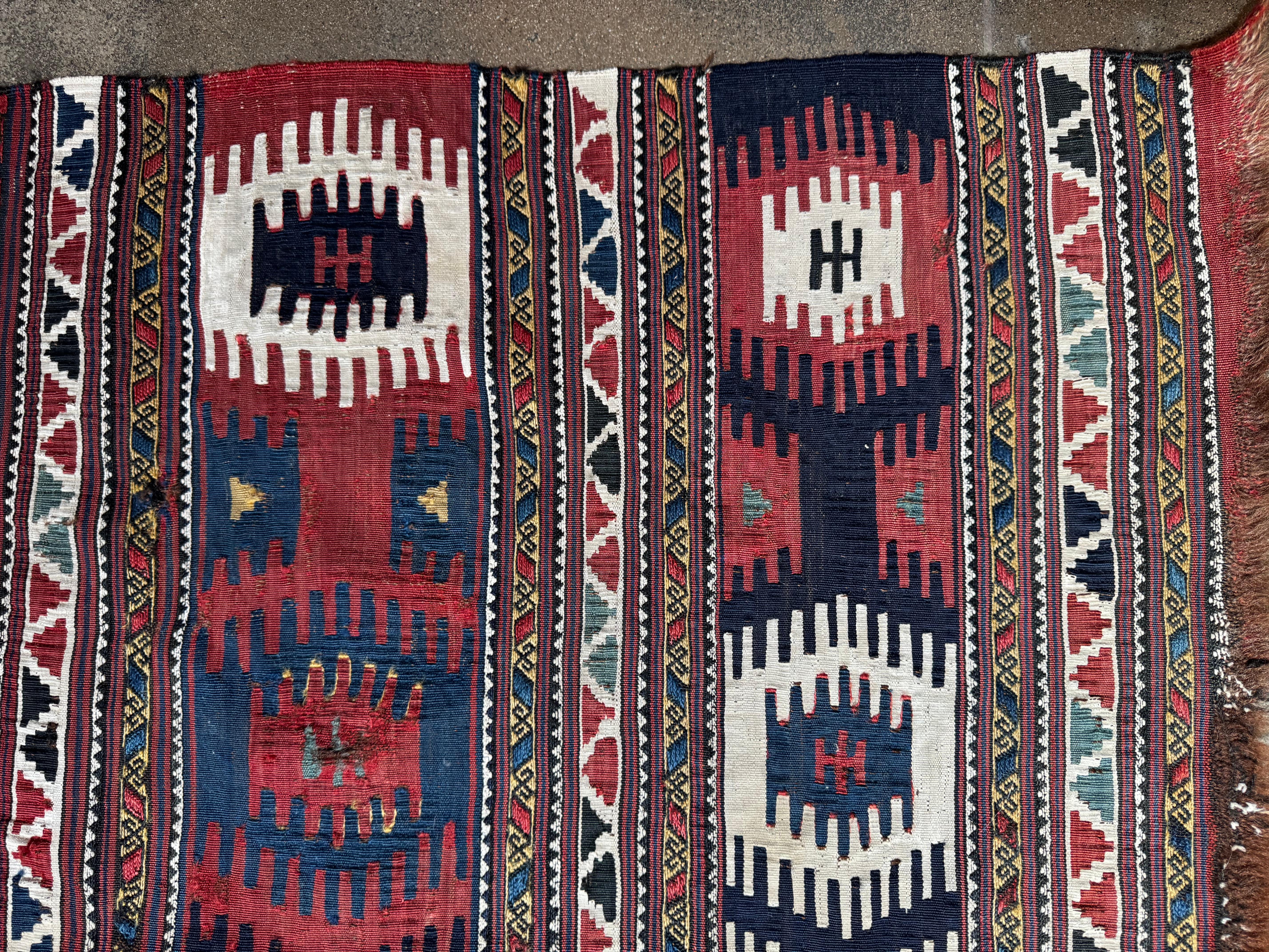 Dieser auffällige Shasavan-Kilim-Teppich im Vintage-Stil zeigt ein reiches geometrisches Motiv in lebhaften Rot-, Indigo-, Elfenbein- und Goldtönen. Die vom Nomadenstamm der Shasavan handgewebten, kühnen, medaillonartigen Muster und die