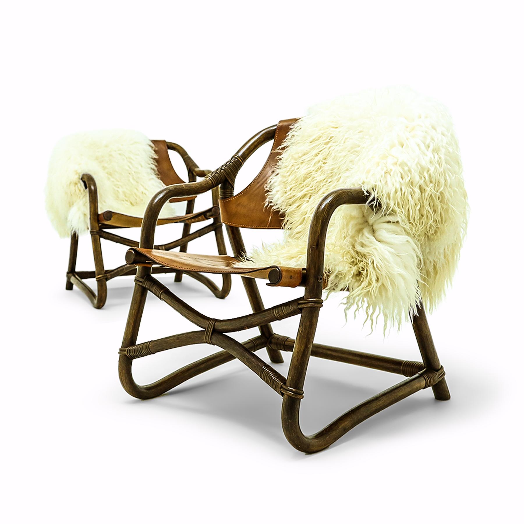 Welcome to Valhalla! Very Nordic in style this pair of chairs features thick leather seats and backs, on bound cane supports with long haired Icelandic sheepskin throws – both throws are included in the price of the set. 

These chairs have been