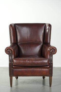 Vintage sheepskin armchair with a high back finished with decorative nails