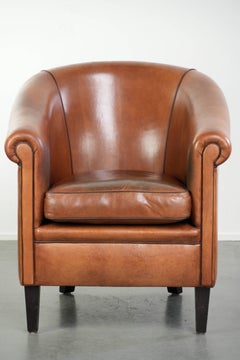 Vintage sheepskin club armchair with a warm colour scheme with black piping