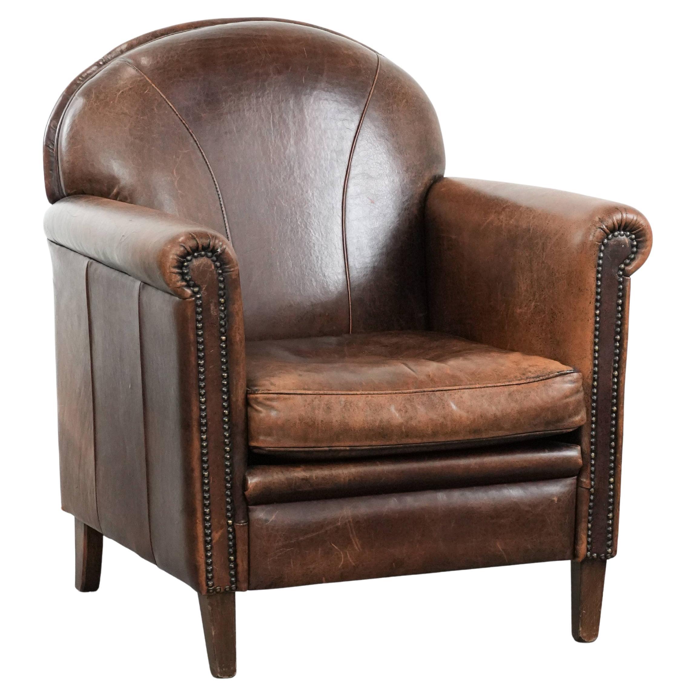 Vintage sheepskin leather armchair with character and warm colours For Sale