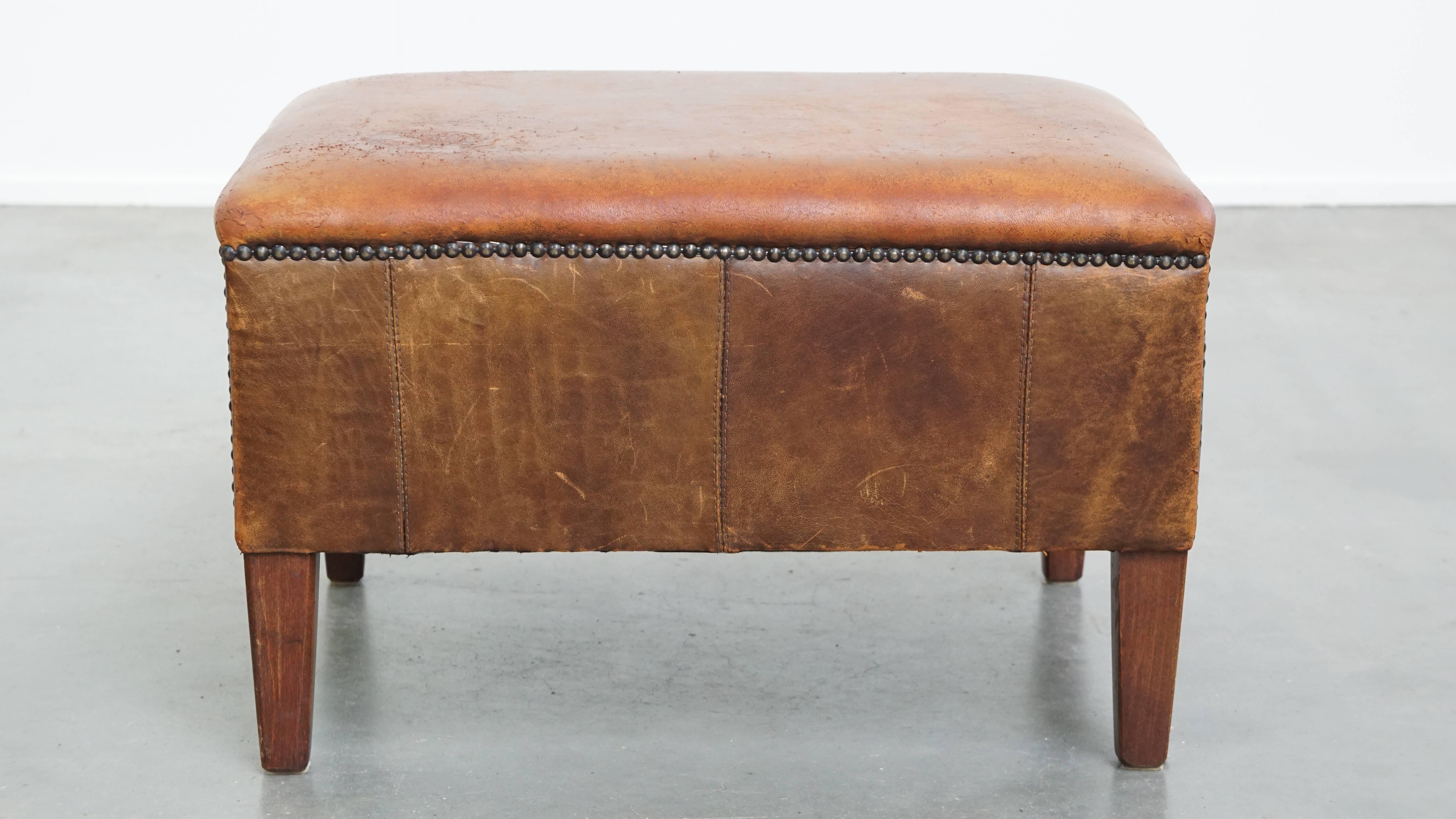 Aquí tienes esta original y resistente otomana vintage, fabricada en piel de oveja auténtica. Un reposapiés de piel de oveja -o hocker- es el compañero perfecto de tu ya cómodo sillón, transformándolo en un verdadero refugio de relajación. Con los