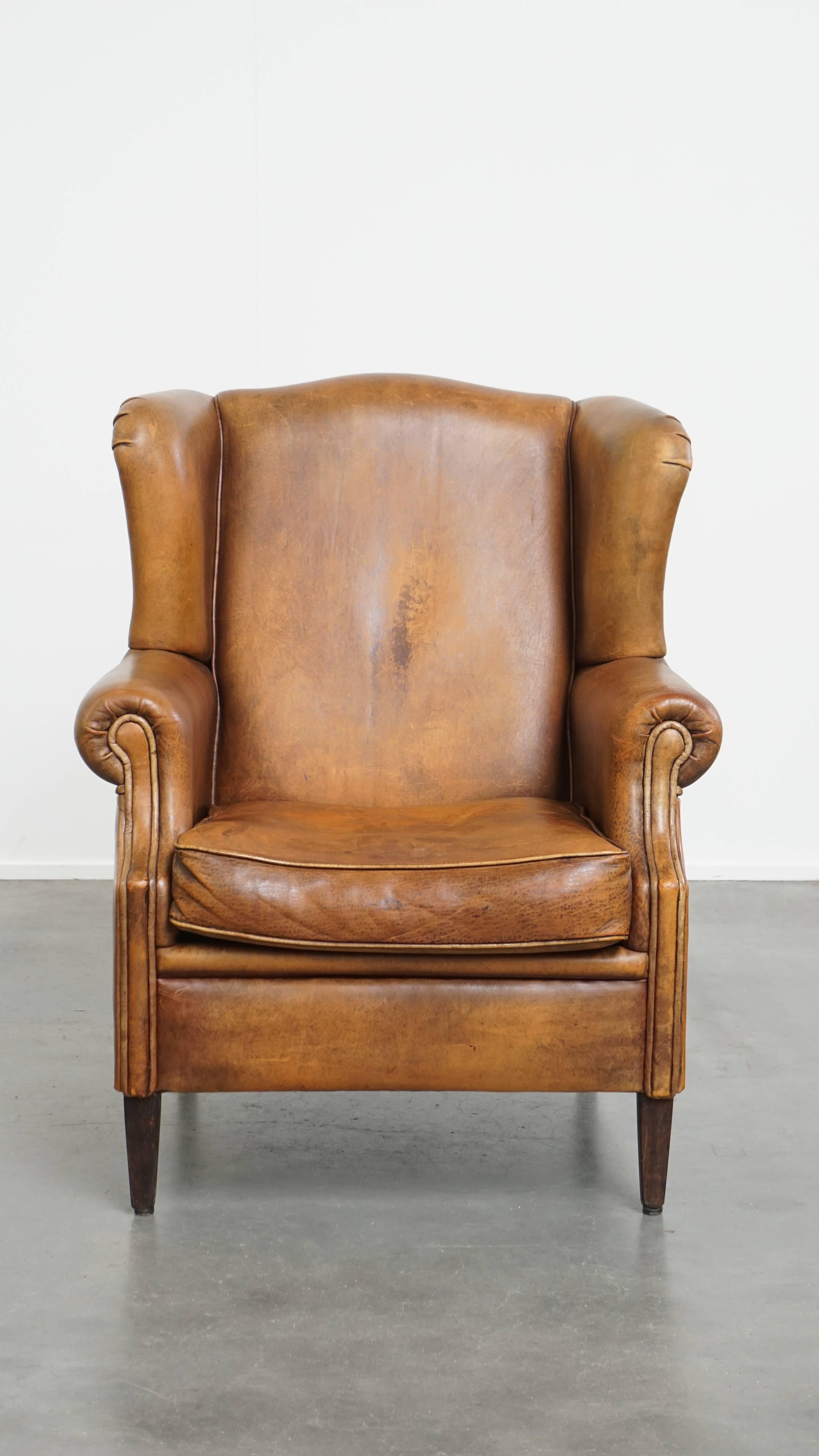 Offered: this wonderful, characterful vintage sheepskin leather wingback armchair with a beautiful patina. This stunning sheepskin leather wingback chair is the perfect addition for lovers of interiors with personality. Its rich colour gives it