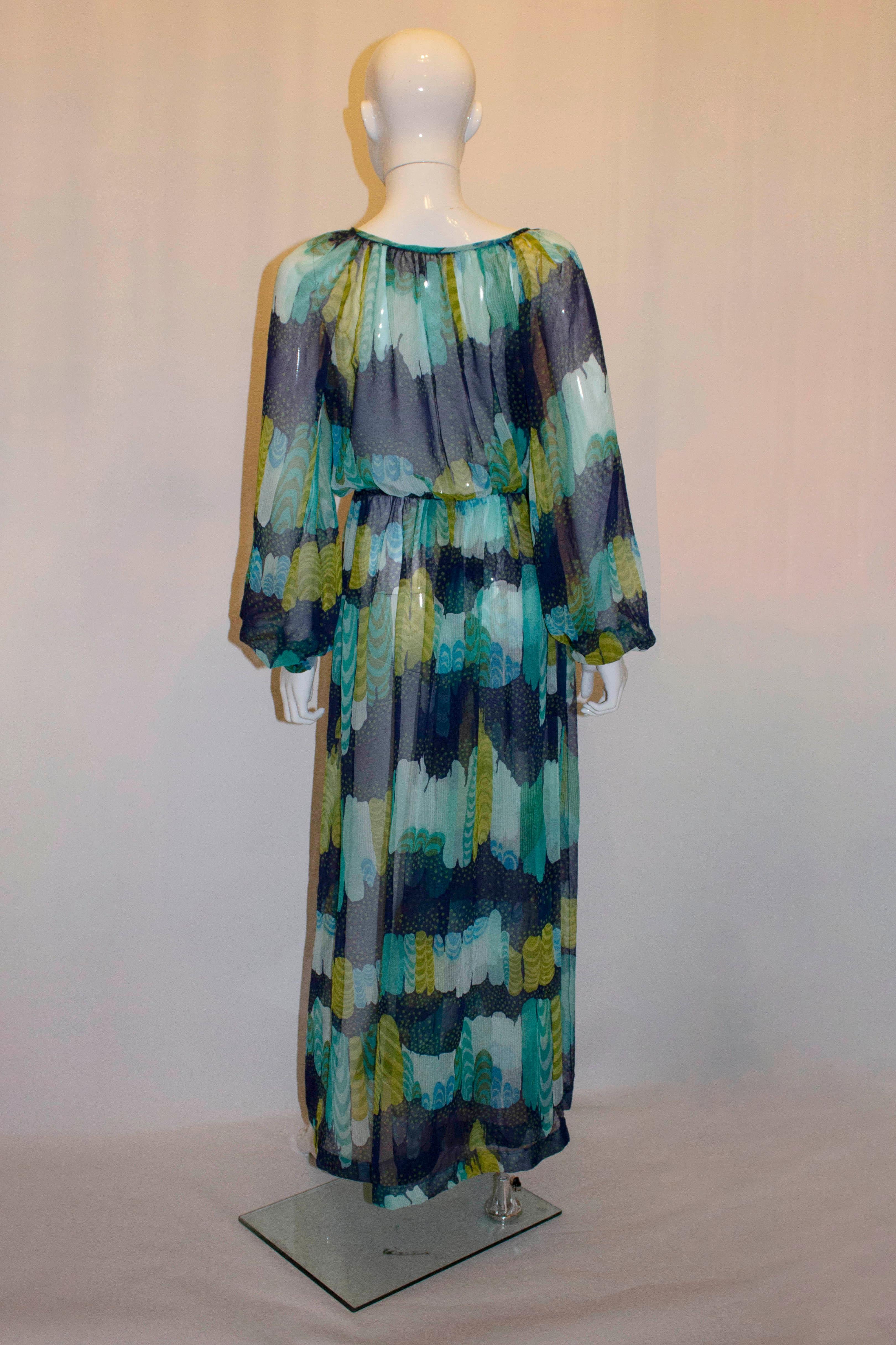 A fun sheer vintage dress from the 1970s.  The dress is in a colourful mix of blue , turquoise, green and yellow.  It has a round neckline and deep cuffs. 
Measurements: Bust up to 42'', waist 22'' - 30'', length 59''