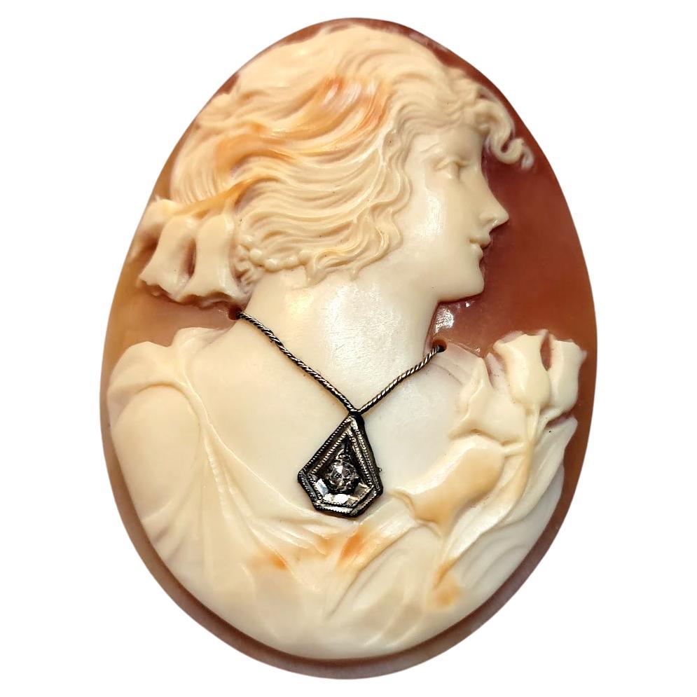 This vintage unmounted Carnelian shell cameo depicting the profile of the beautiful young lady is very well carved in exquisite detail. The cameo is decorated with a 0.03 ct diamond (2mm). This cameo dates back to around the 1910s-1930s.
The carving