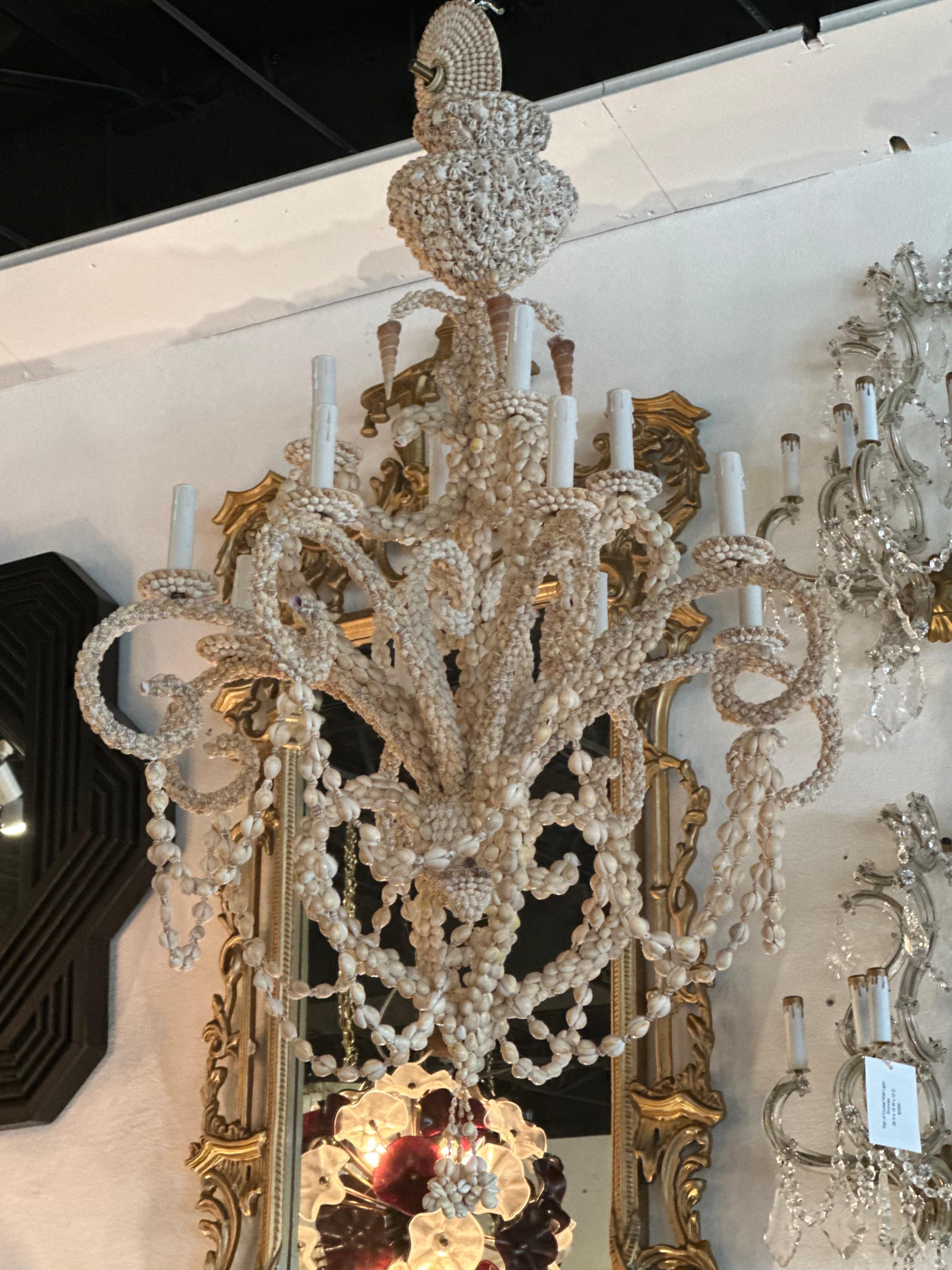 Vintage Palm Beach shell seashell encrusted 12 light chandelier. Tested working order. New candelabra sleeves. No damage or missing shells. Comes with original matching seashell ceiling cap. Matching wall sconces at time of listing. Dimensions: 47 H