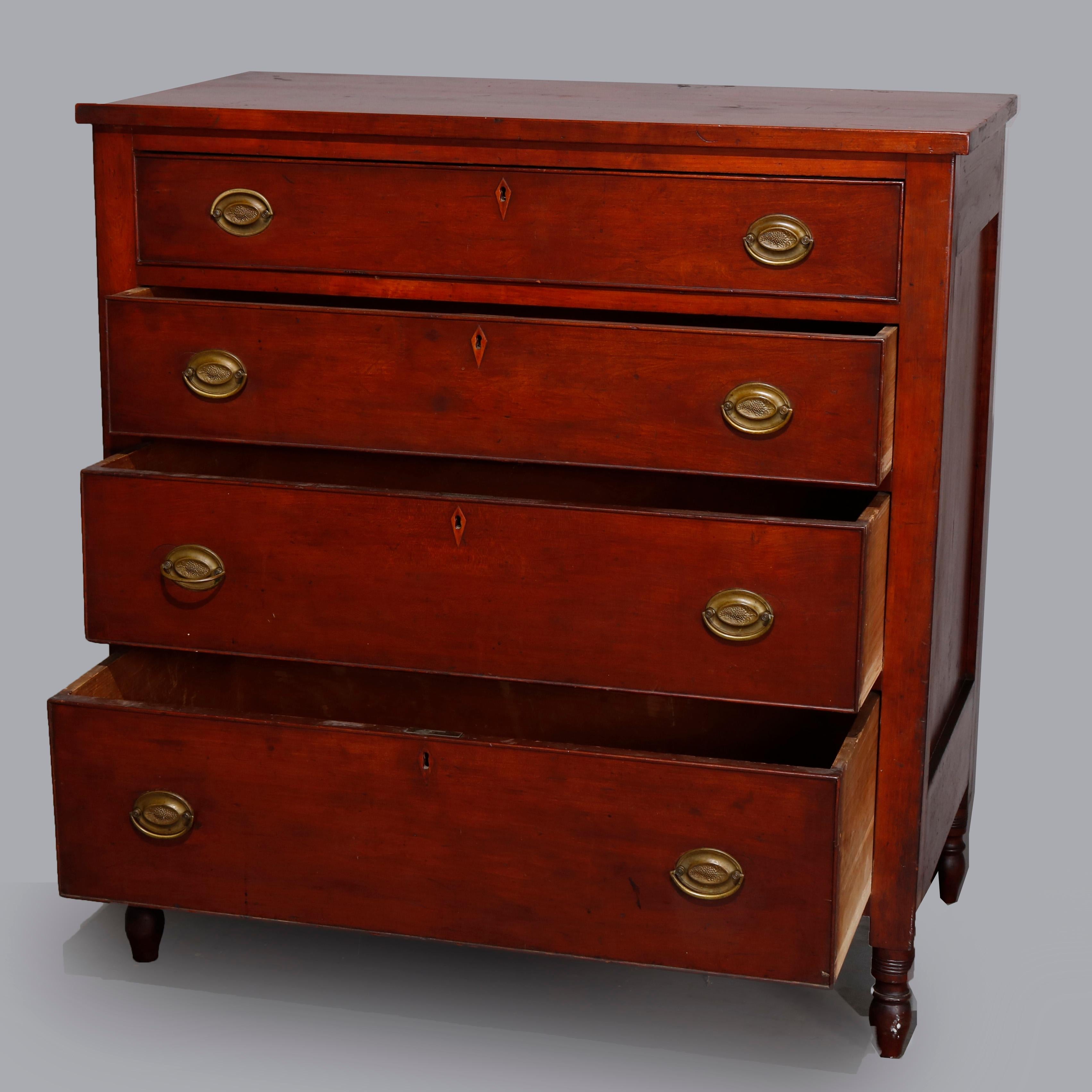 An antique Sheraton chest of drawers offers cherry construction with four graduated long drawers having cast bronze pulls and inlaid escutcheons, raised on turned legs, circa 1930

Measures: 43.5