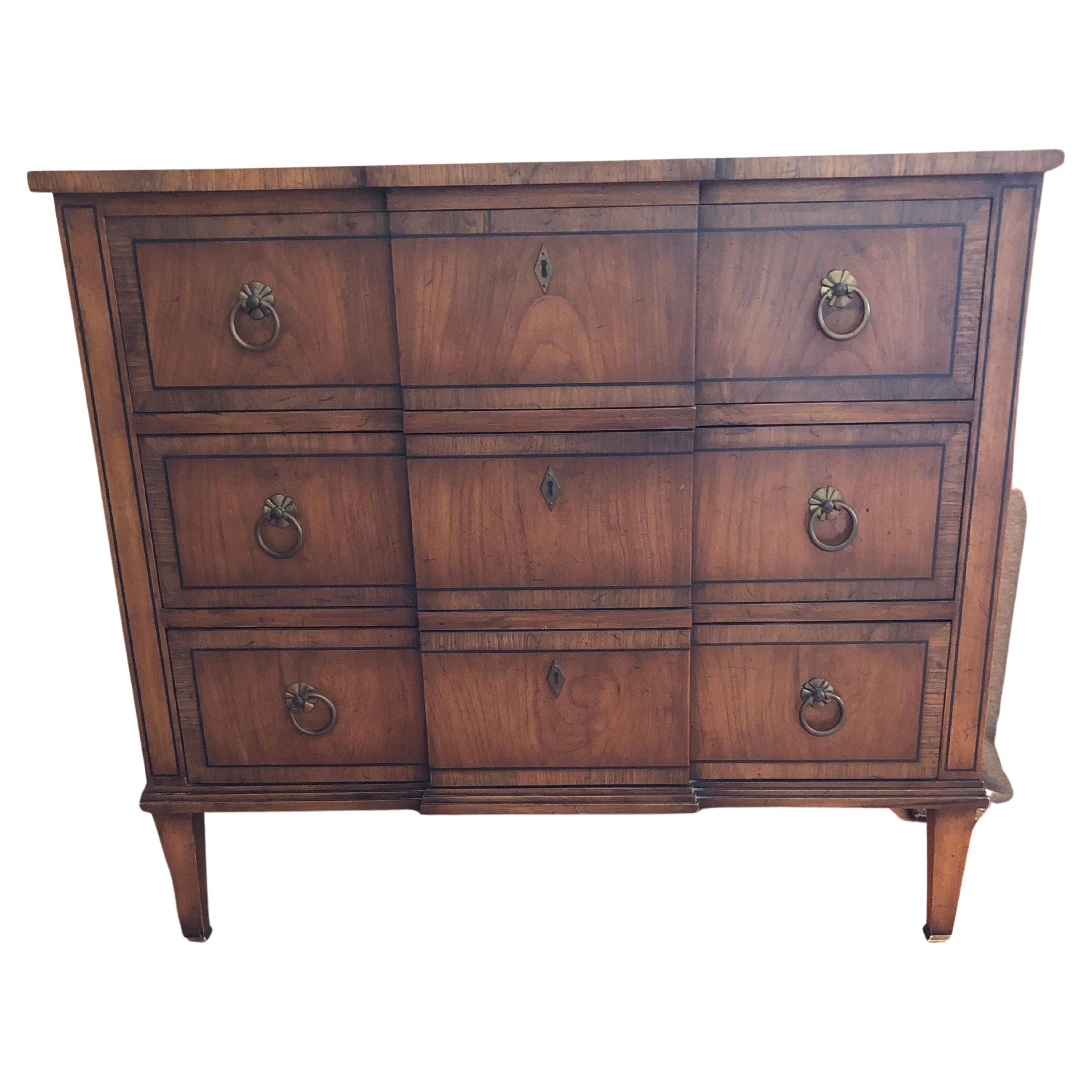 Classic Sheraton style 3 drawer commode having lovely darker inlay wood decoration and original round brass hardware.
Measures: 18 D except for middle that juts out 1/2 inch.
 