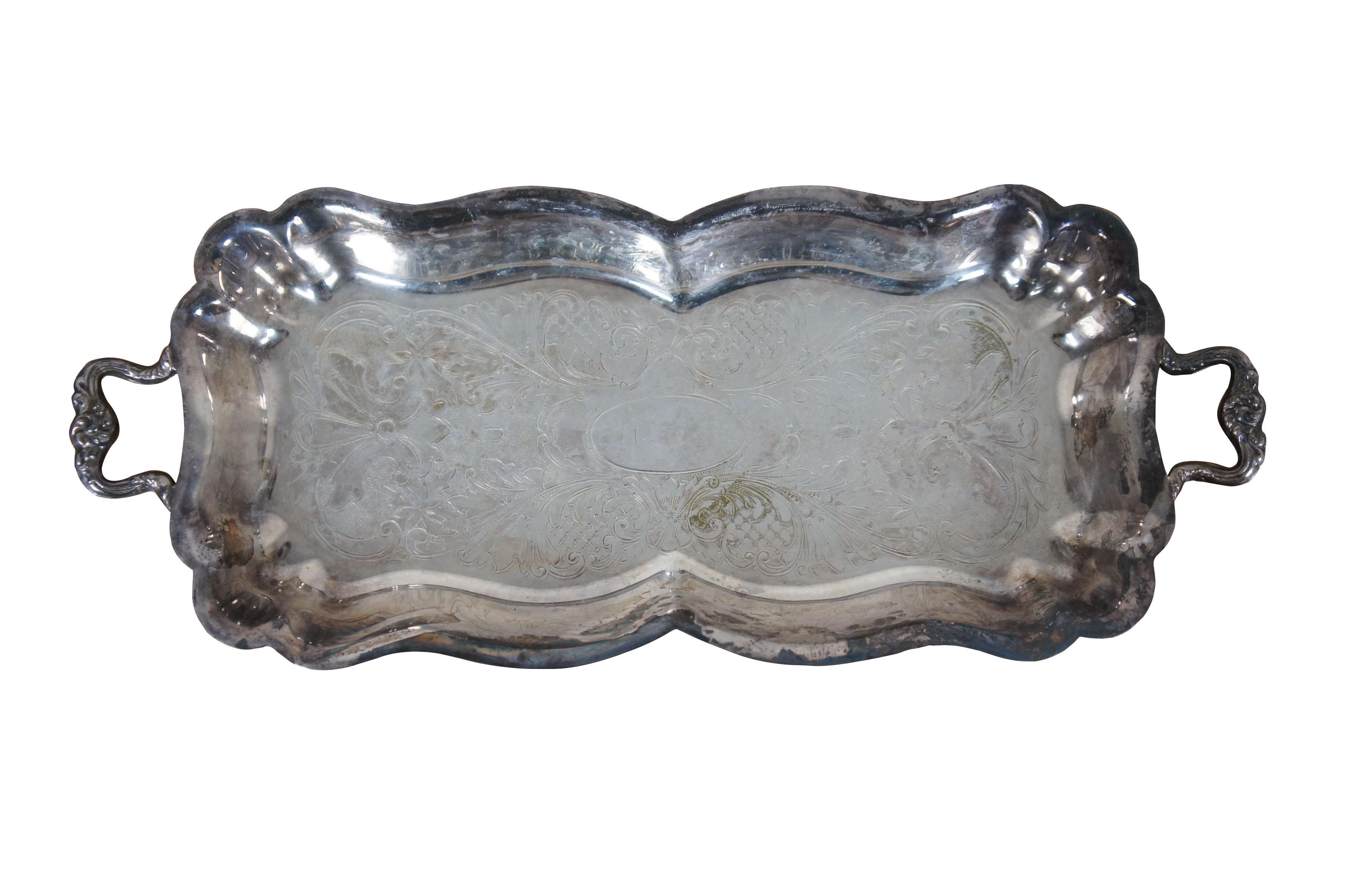 Mid 20th century relish dish / small serving tray by Sheridan Silver Co and cake server by the National Silver Company. Tray features footed base, scalloped edges and etched scallops and florals on body and handles. Cake server features a pierced