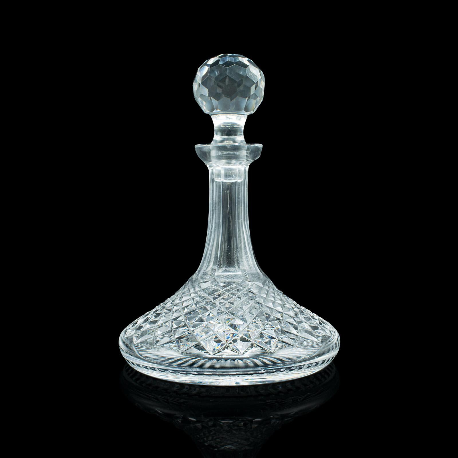 This is a vintage ship's decanter. An English, cut glass spirit or wine vessel, dating to the mid 20th century, circa 1950.

Beautifully cut glass in the traditional 'ship's decanter' wide-base form
Displays a desirable aged patina and in fine