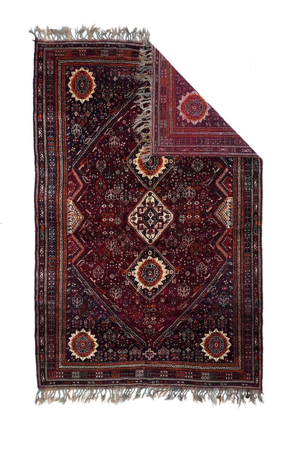 Vintage Shiraz Rug 7'0'' x 10'7''. With all the finishing tassels intact, this extra-large nomadic piece shows a deep red fiekld controlled by a tripartite pole medallion of minutely stepped near-diamond octagons enclosing either the 