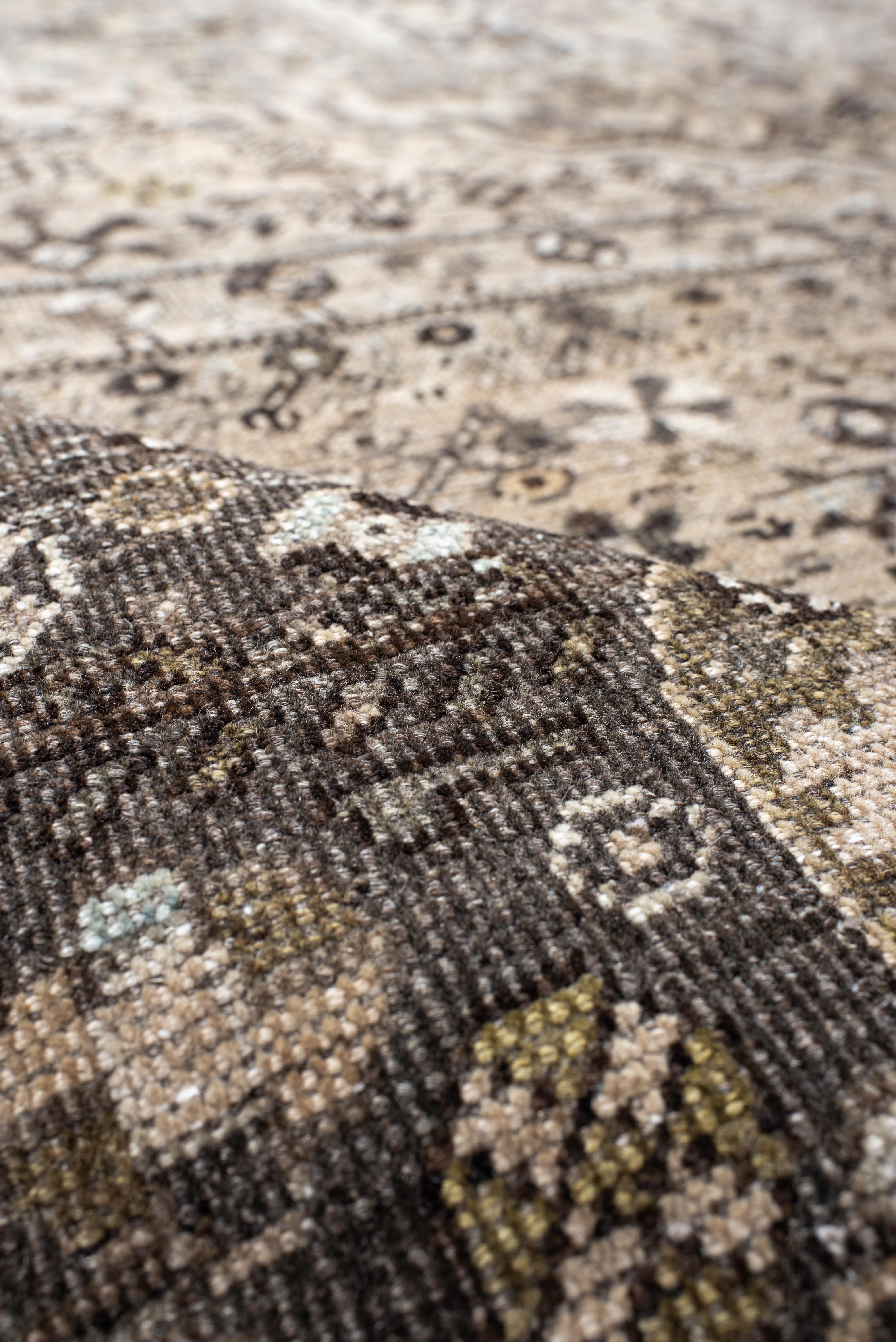 Questo tappeto vintage Shiraz presenta un campo audace color antracite ammorbidito da un ampio medaglione centrale nei colori sfumati del taupe, del cenere e dell'argento pallido. Intricati simboli tribali e fiori stilizzati sono sparsi nella
