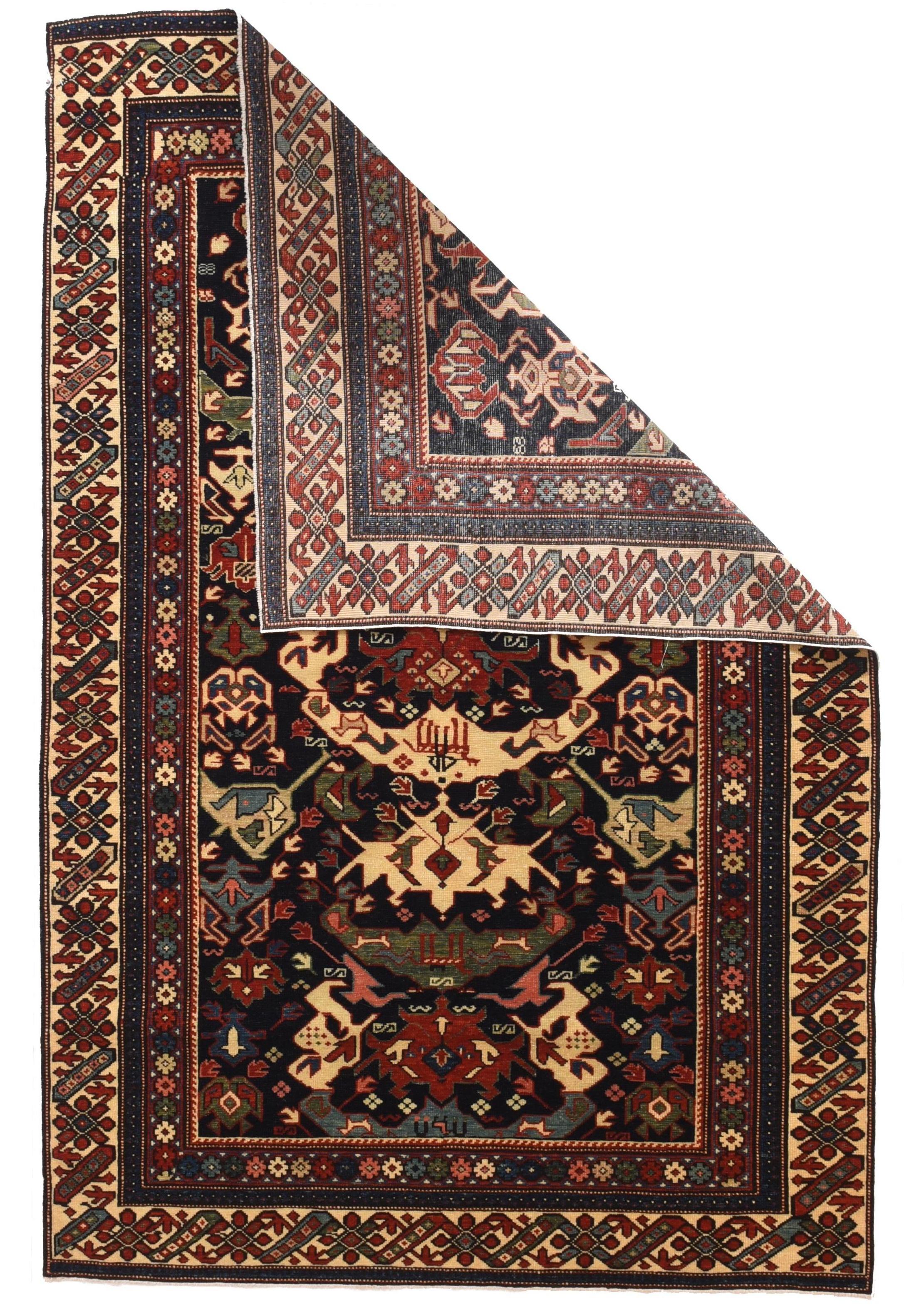 This east Caucasian, moderately finely woven, good condition scatter combines an ivory ground rosette and diagonal bar border taken from Kuba Chi-Chi rugs, with a dark blue field decorated by a complex ascending pattern of various types of geometric