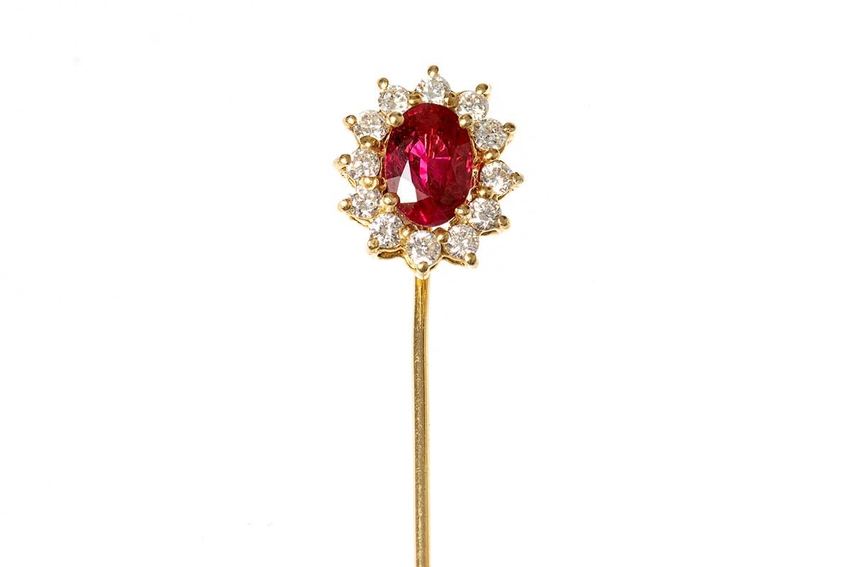 An 18 carat yellow gold mounted tie pin with a central oval shaped Siam ruby surrounded by twelve small brilliant cut diamonds in a claw setting.
Measures 8mm in width x 10mm in height.
1970’s vintage piece.
20th century, English circa