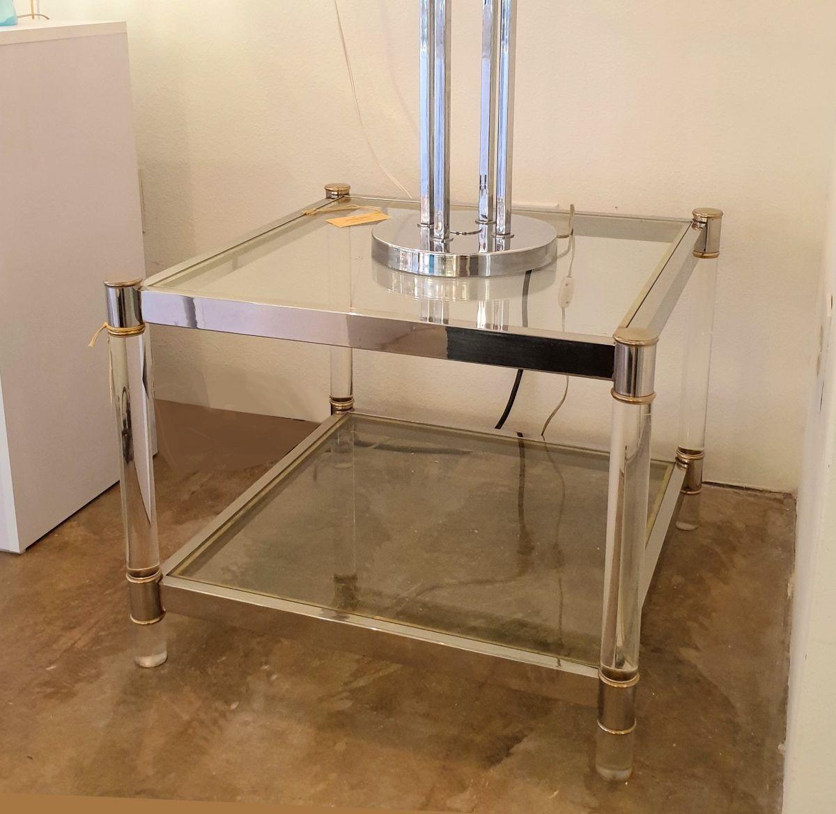 Vintage chrome, lucite and glass square side table with brass and chrome accents, attributed to Maison Jansen. France, 1970s.
The coffee table has 2 shelves, in transparent glass: lucite column legs and a two-toned metal finish.
A nice medium size