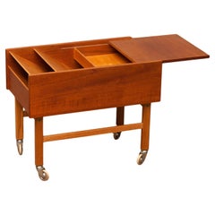 Mesa auxiliar vintage con compartimento para revistas y tablero deslizante en teca. Dinamarca 1960