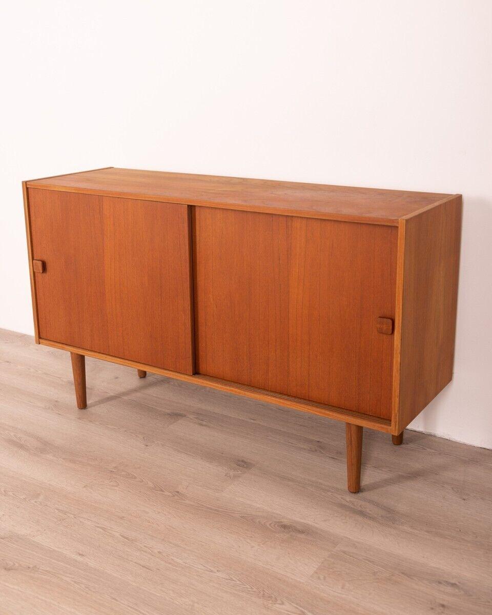 Sideboard sideboard in teak wood, with two sliding doors and two internal shelves, Danish design, 1960s.

Condition: In excellent condition, it may show slight signs of wear caused by time.

Dimensions: height 73 cm; width 122cm; depth