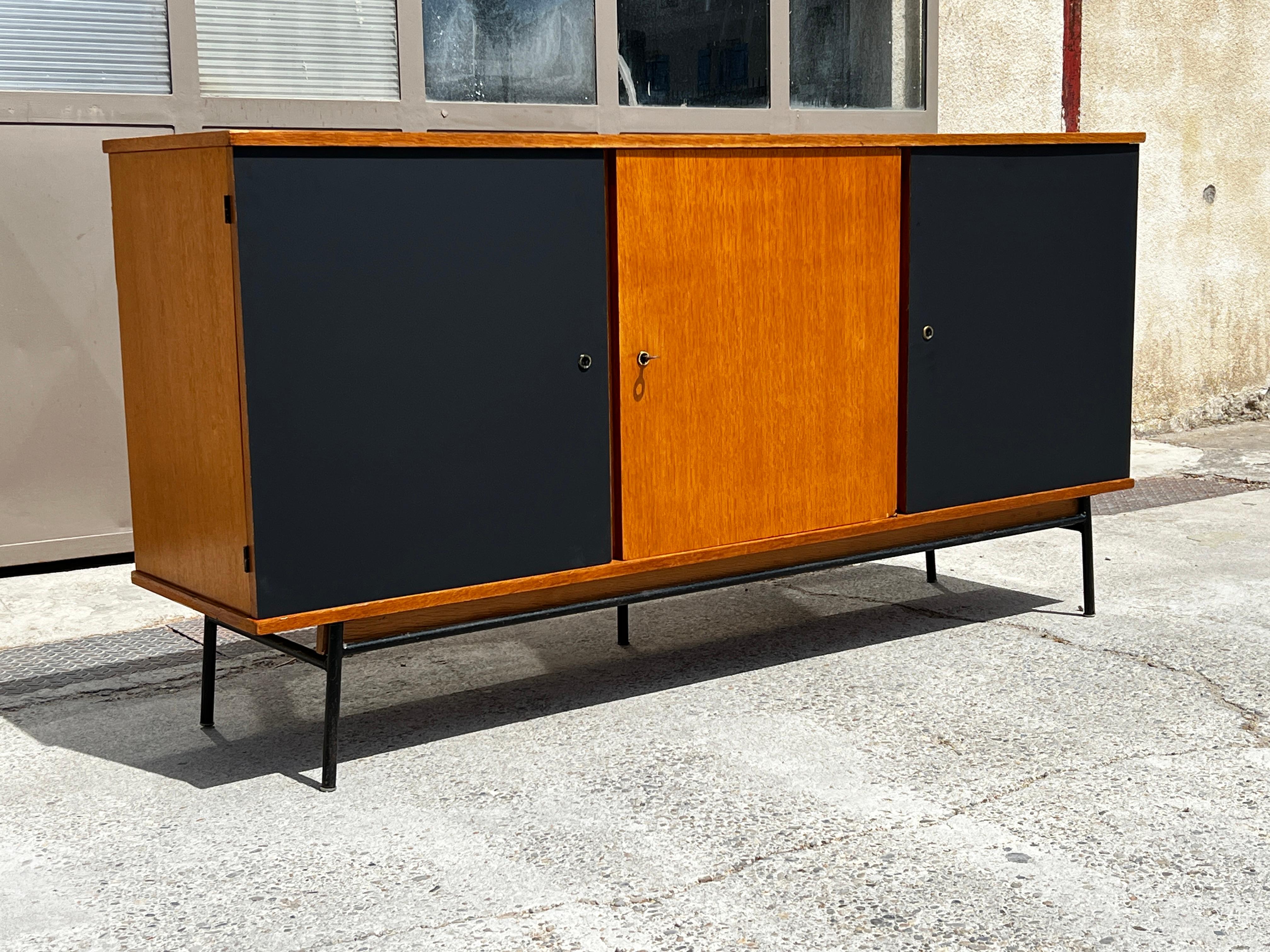 French modernist sideboard albert ducrot for ducal 1950 in blond wood and black mat laminate, with 3 doors. Black metal base. Inside drawers and shelves. Nice workmanship and good condition.