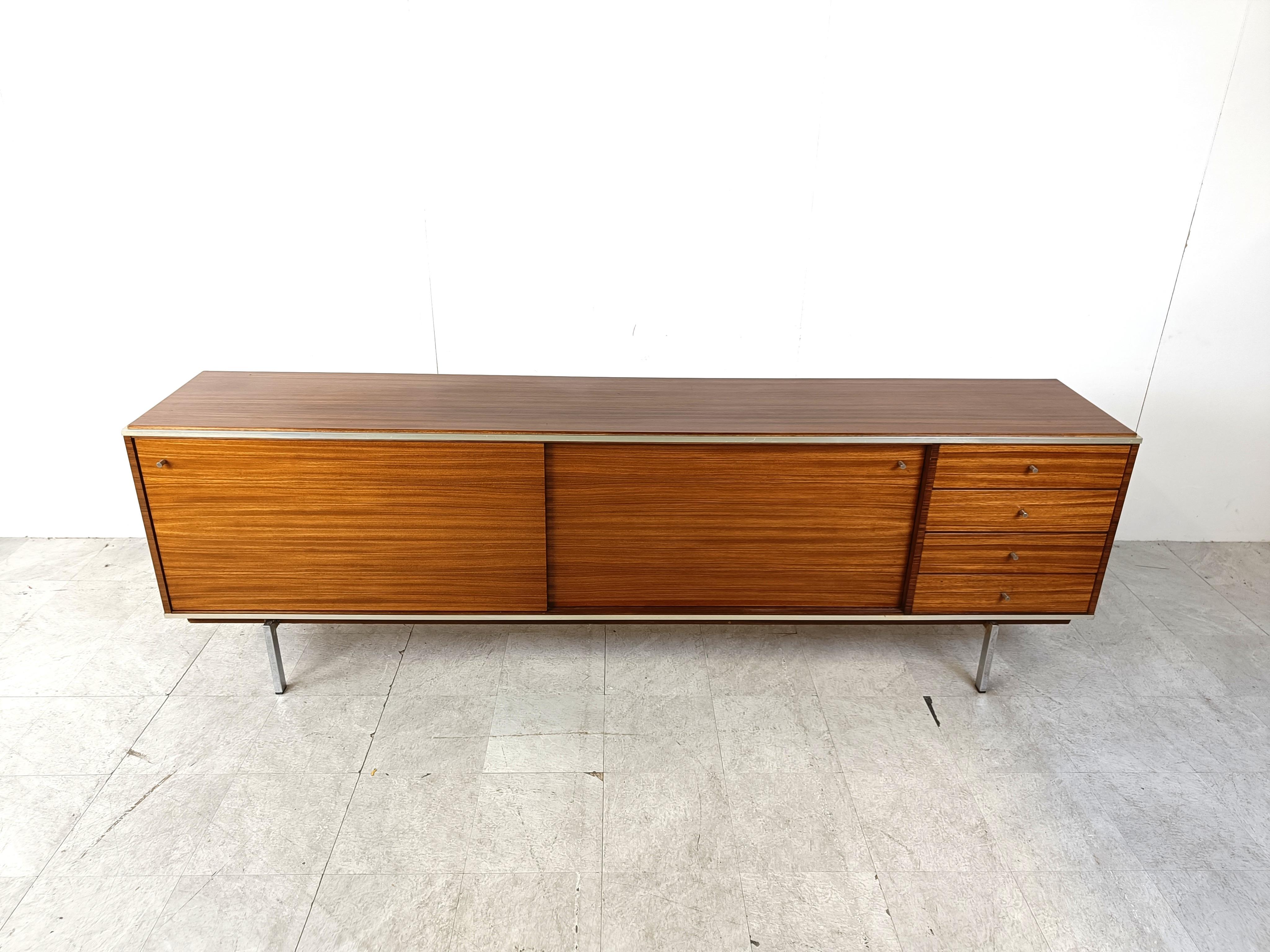 Mid century modern sideboard by Pieter de Bruyne for AL meubel.

Beautiful timeless design with a beautiful wood patern.

Chromed steel legs.

Good condition with normal age related wear.

1960s - Belgium

Dimensions:
Lenght: 255cm
Height:
