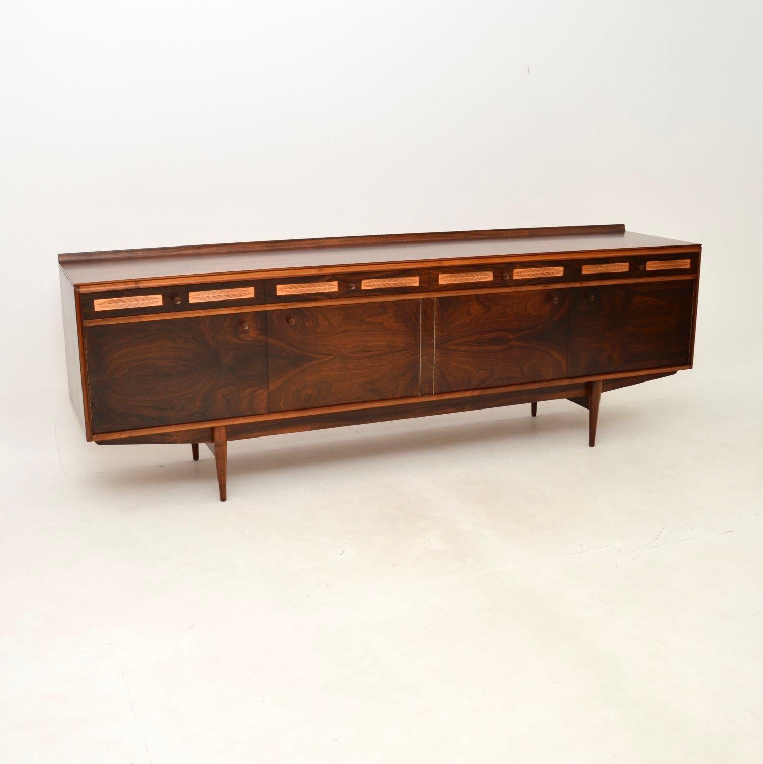 An exceptional vintage sideboard by Robert Heritage for Archie Shine. This was made in London, it dates from the 1960’s.

This was part of the “Berkshire” range, distinctive for the copper inlays on the top drawers depicting feather motifs. The
