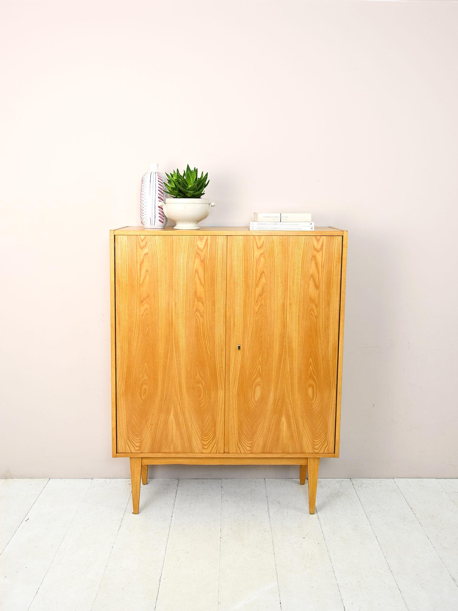Scandinavian vintage modernism cabinet.
This retro-flavored cabinet features simple and elegant lines.
It consists of a storage compartment closed by lockable hinged doors.
Tapered legs lighten the structure.
Perfect as a document cabinet, but