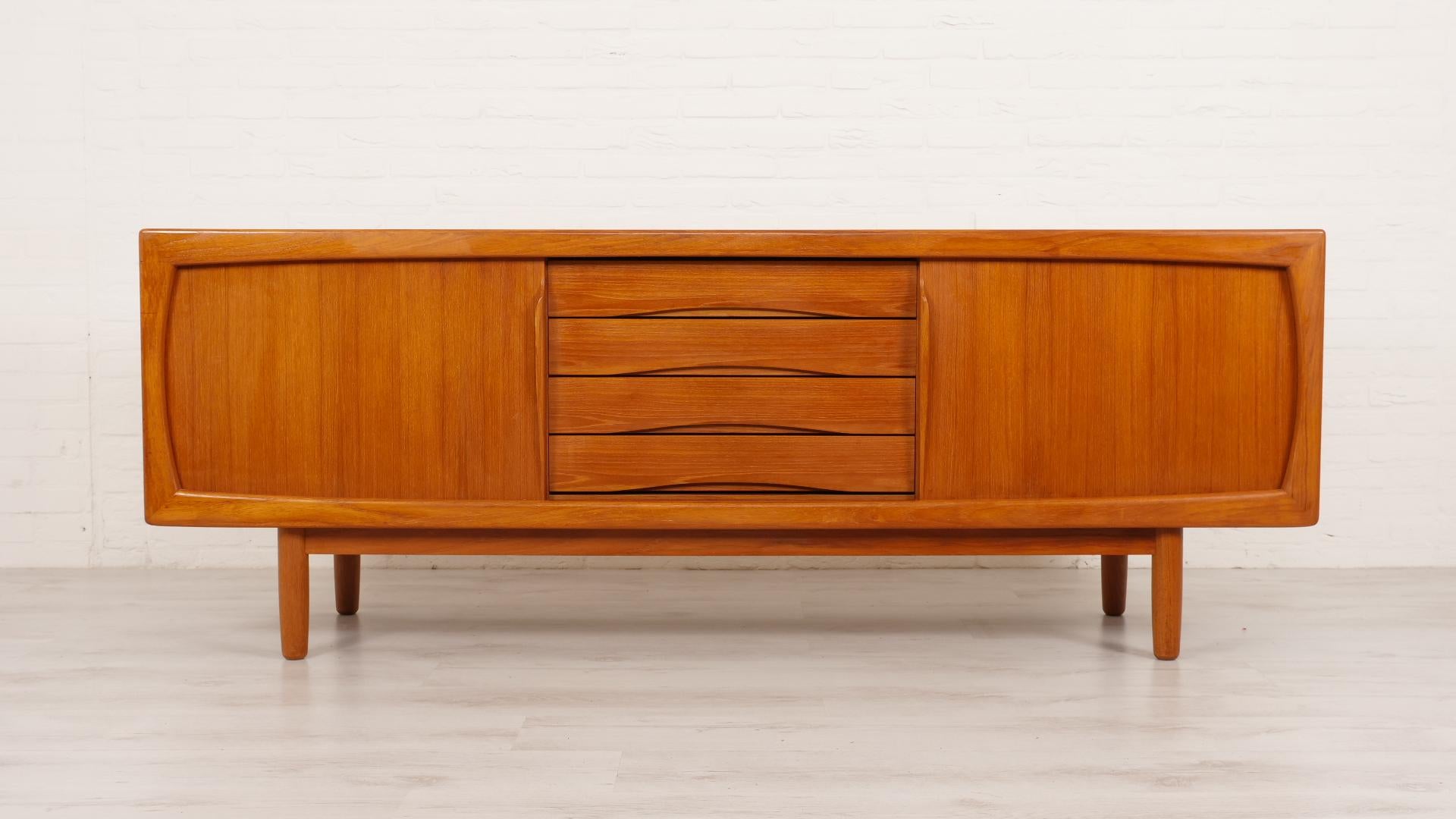 Beautiful teak Danish design sideboard in perfect condition. This sideboard has an impressive size and is very functional. The sideboard has two sliding doors and four drawers. The drawers have beautiful handles. The rounded edges and conical legs