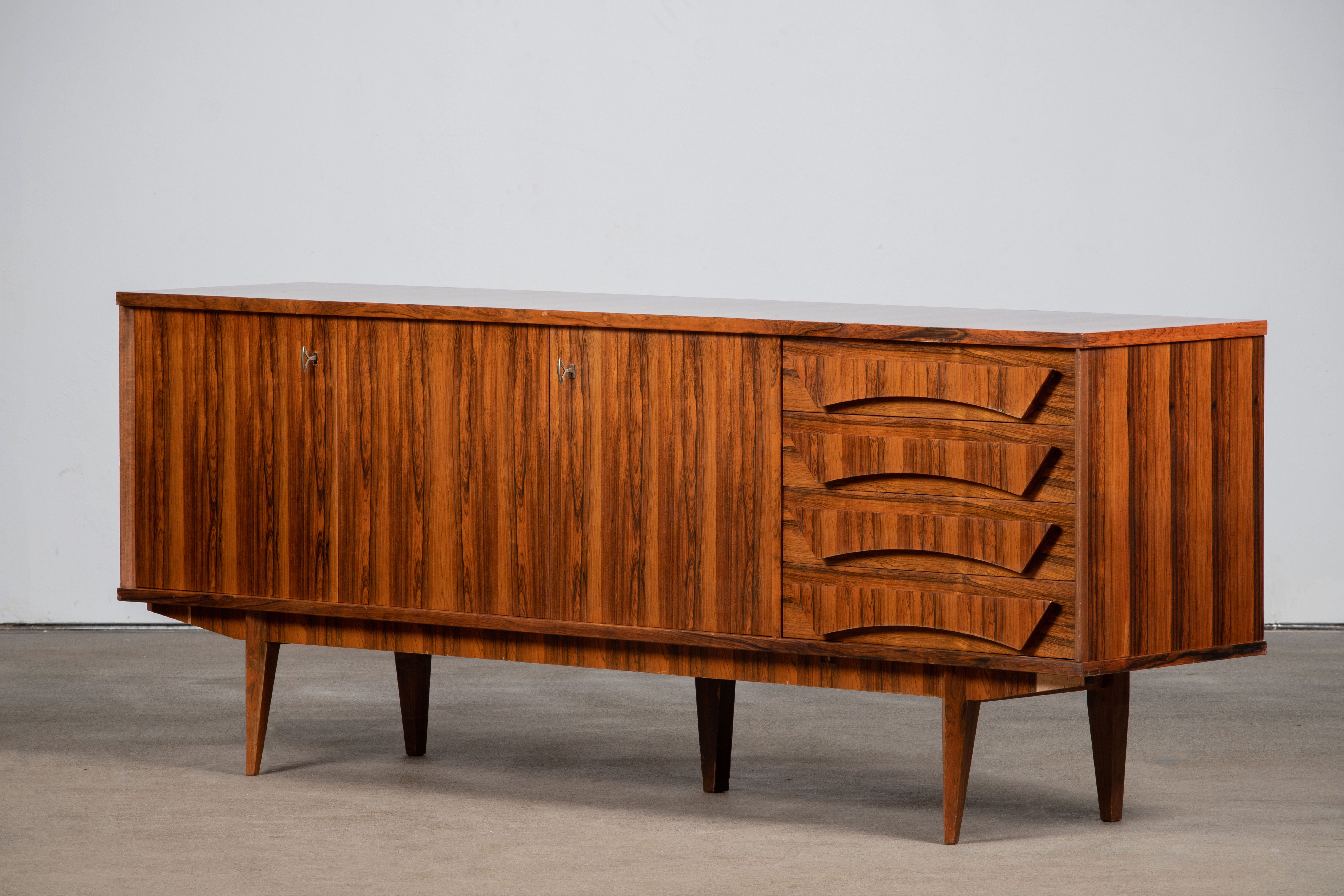 MidCentury Rosewood sideboard.
An elegant piece offering ample storage, the veneer is very ornemental
Good condition with minor wear.