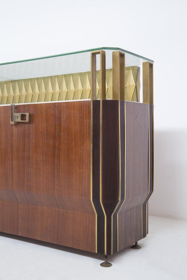 Vintage sideboard manufactured by Dassi Mobili Moderni in the 50's.
The sideboard is made of various essences of maple wood, of which the central body of the cabinet is composed of four doors, containing two storage spaces.
The feet and finishes are