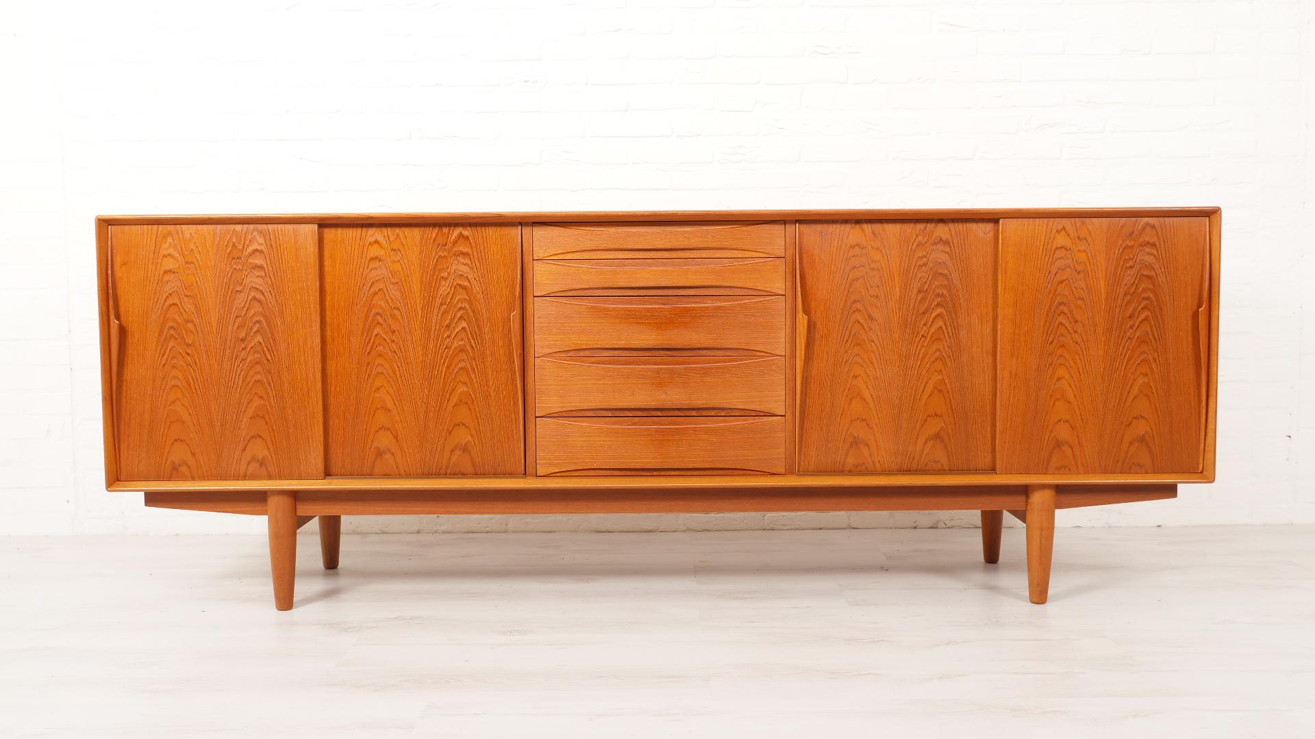 This vintage teak sideboard by Arne Vodder for renowned brand Dyrlund is a true showpiece from 1960. With its clean lines and craftsmanship, this Danish furniture exudes timeless elegance. The sideboard offers both style and functionality, perfect